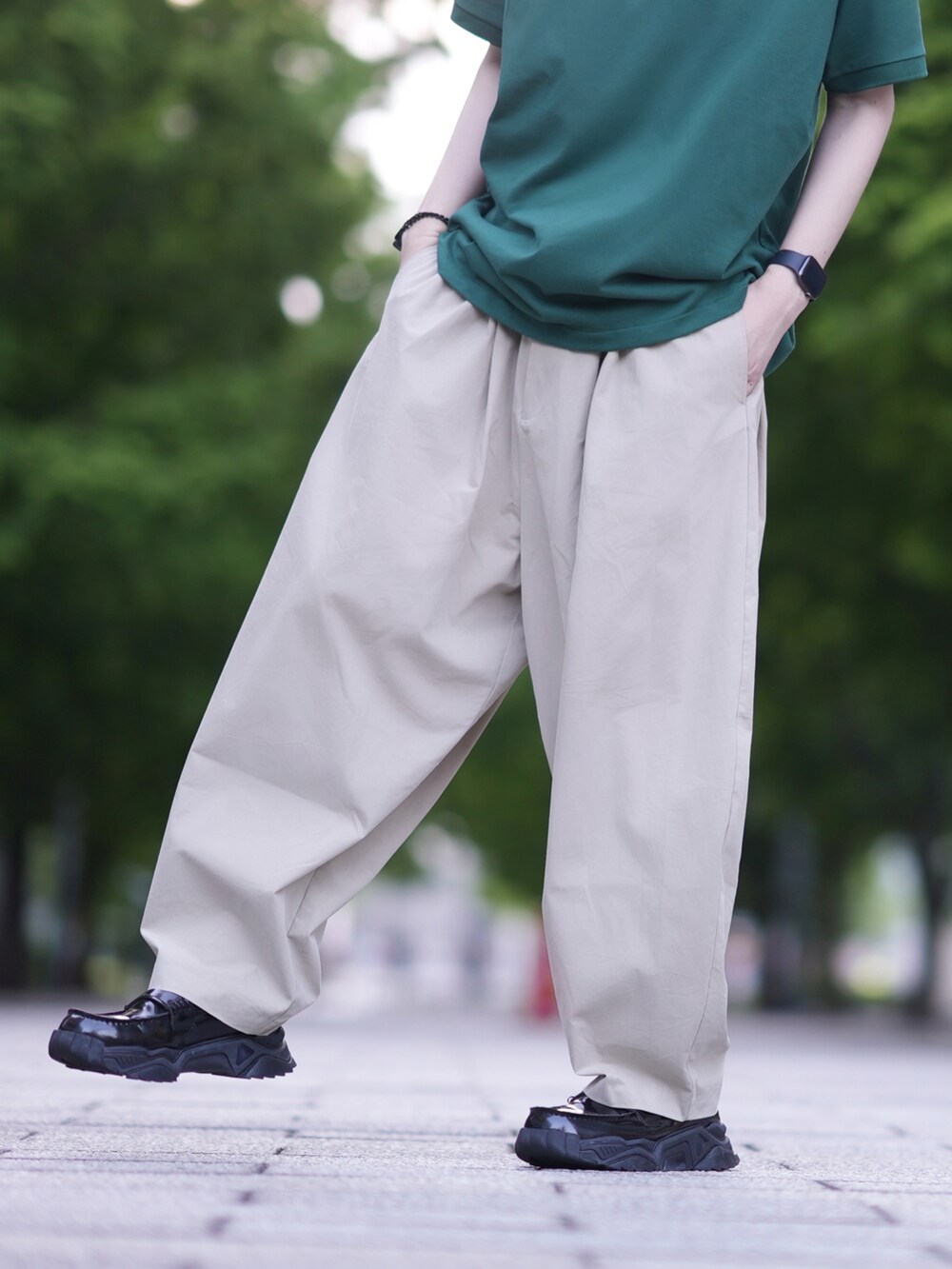 グリーン系のポロシャツ、ベージュ系のその他パンツ、ブラック系のローファーを着用したメンズの夏コーディネートの4枚目の写真