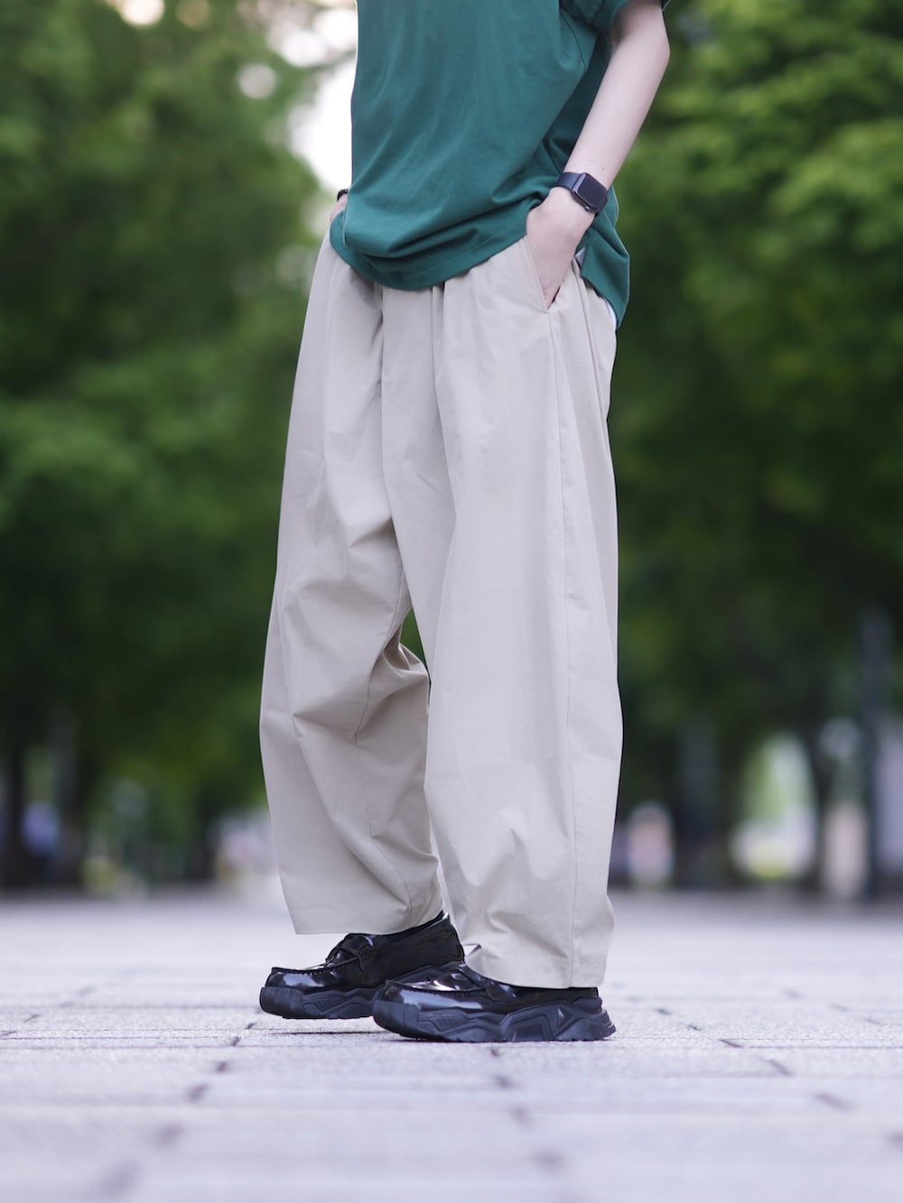 グリーン系のポロシャツ、ベージュ系のその他パンツ、ブラック系のローファーを着用したメンズの夏コーディネートの3枚目の写真