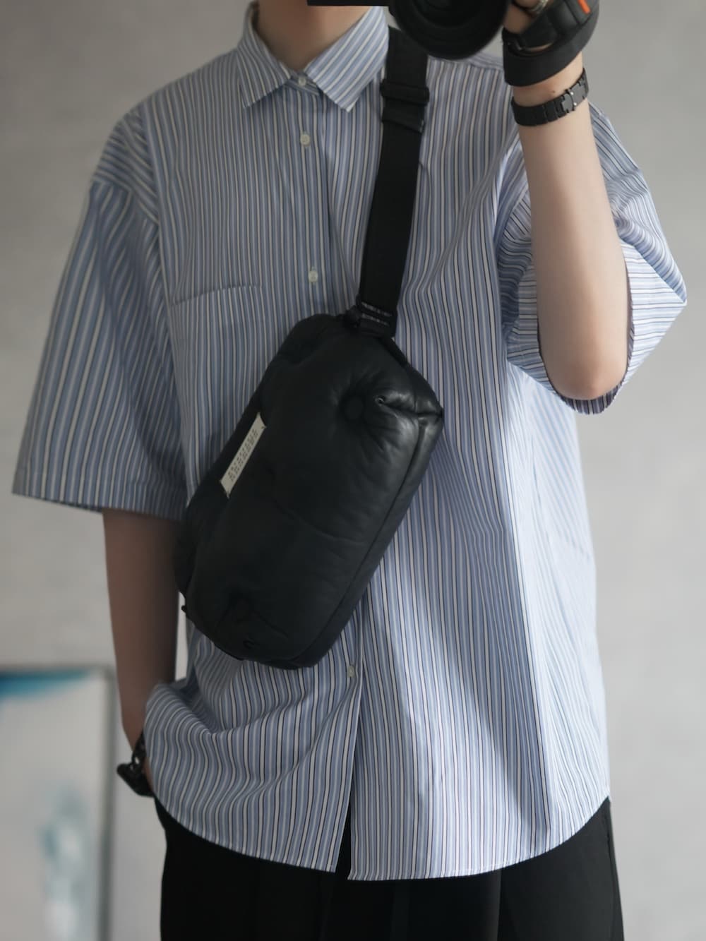 ブルー系のシャツ/ブラウス、ブラック系のカーゴパンツ、ベージュ系のスニーカーを着用したメンズの夏コーディネートの2枚目の写真