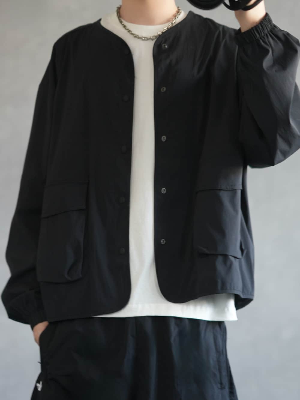 ブラック系のジャケット/アウター、ホワイト系のタンクトップ、ブラック系のスウェットパンツを着用したメンズの春コーディネートの2枚目の写真