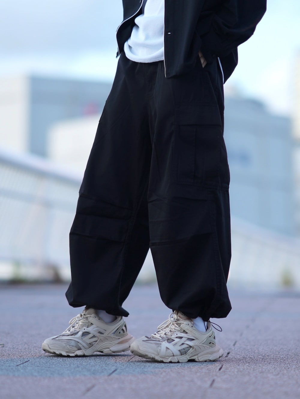 ブラック系のシャツ/ブラウス、ホワイト系のタンクトップ、ブラック系のカーゴパンツを着用したメンズの秋コーディネートの3枚目の写真