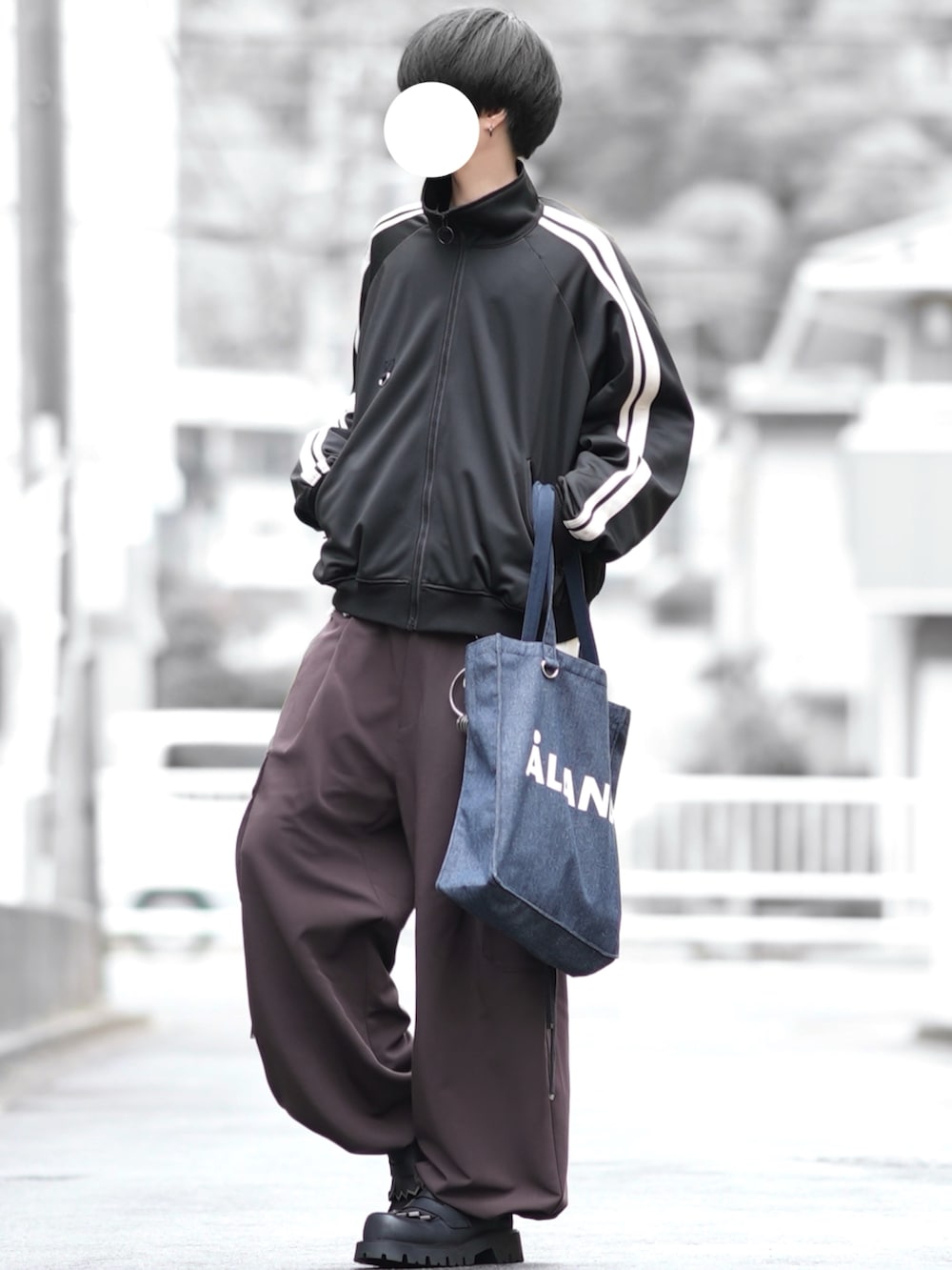 ブラック系のジャージ、ブルー系のトートバッグ、ブラウン系のカーゴパンツを着用したメンズの冬コーディネートの2枚目の写真