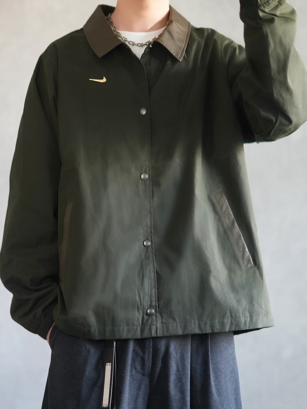 グリーン系のその他アウター、ホワイト系のスウェット、グレー系のスラックスを着用したメンズの冬コーディネートの3枚目の写真