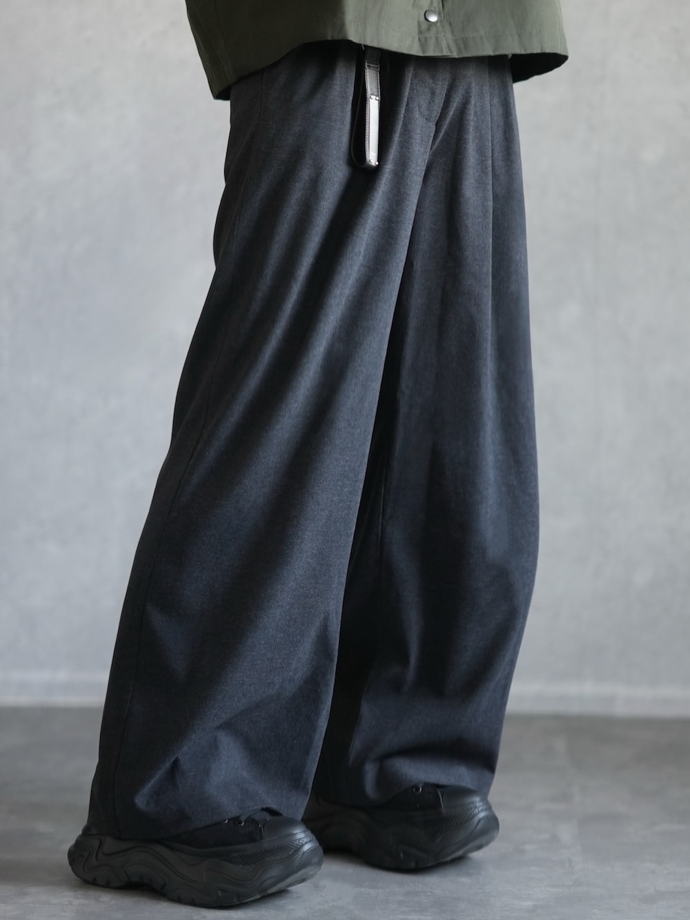 グリーン系のその他アウター、ホワイト系のスウェット、グレー系のスラックスを着用したメンズの冬コーディネートの4枚目の写真