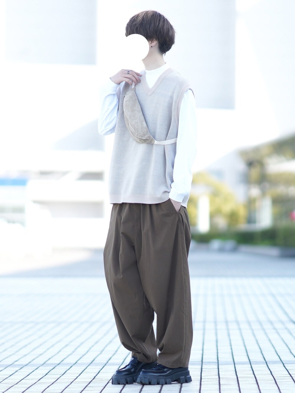 ベージュ系のベスト、ホワイト系のTシャツ/カットソー、ブラウン系のその他パンツを着用したメンズの春コーディネートの2枚目の写真