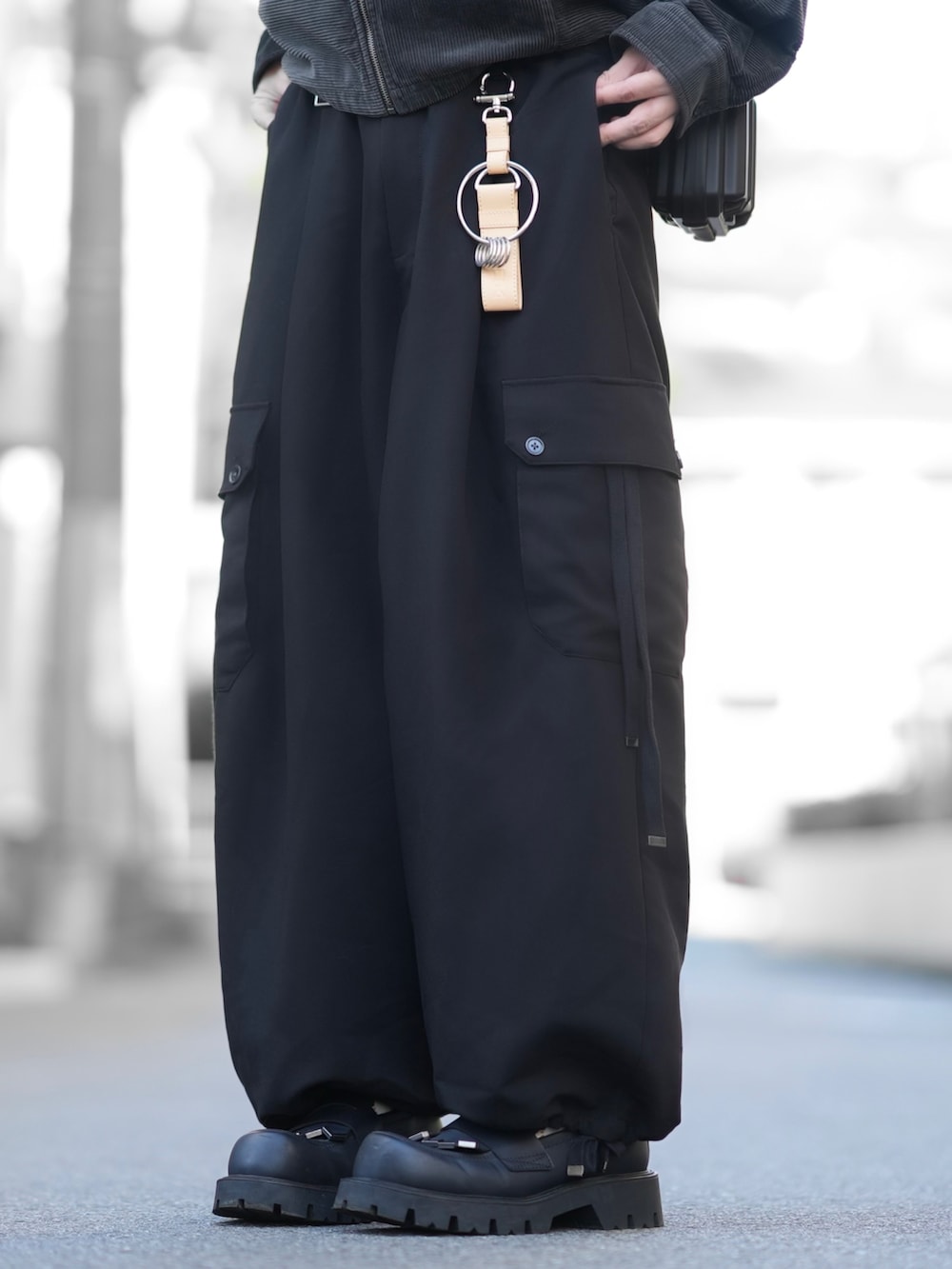 グレー系のブルゾン、ホワイト系のTシャツ/カットソー、ブラック系のカーゴパンツを着用したメンズの秋コーディネートの3枚目の写真