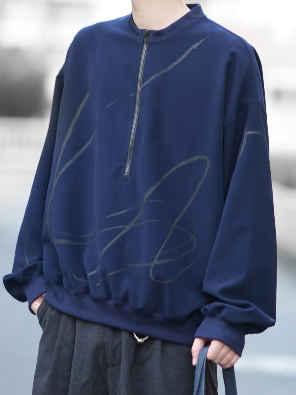 ブルー系のスウェット、グレー系のスラックス、ブラック系のローファーを着用したメンズの秋コーディネートの3枚目の写真