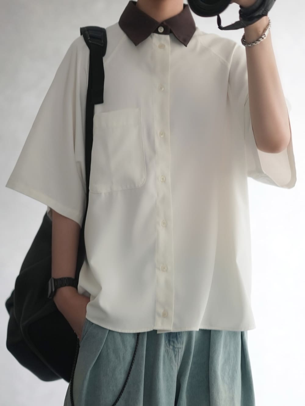 ホワイト系のシャツ/ブラウス、ブルー系のデニムパンツ、ブラック系のシューズを着用したメンズの夏コーディネートの2枚目の写真