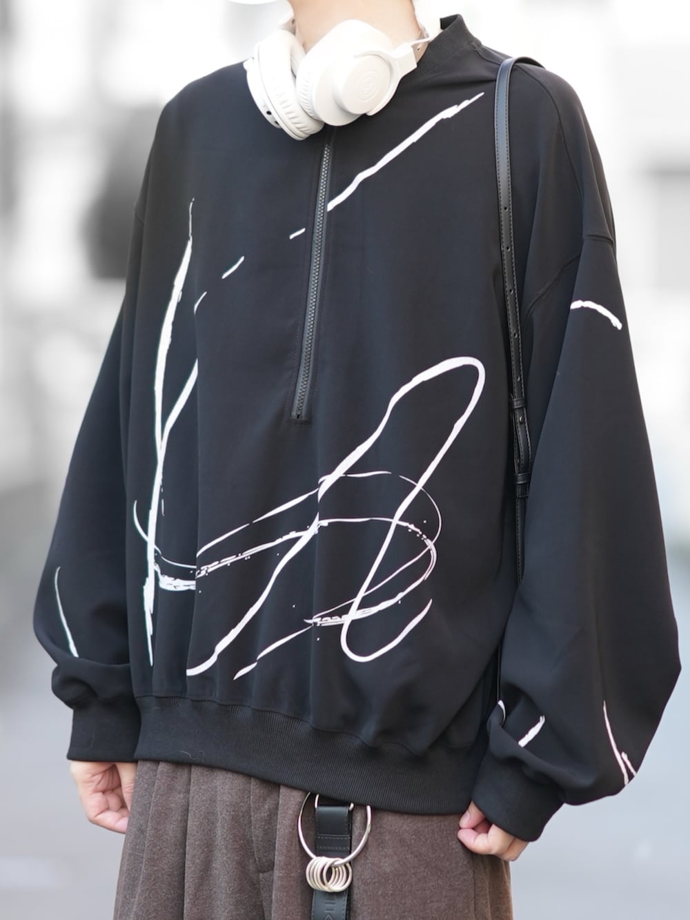 ブラック系のスウェット、ブラウン系のパンツ、ブラック系のローファーを着用したメンズの秋コーディネートの2枚目の写真