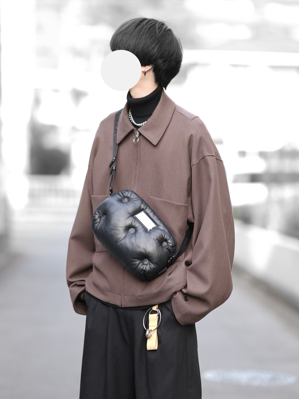 ブラウン系のブルゾン、ブラック系のニット/セーター、ブラック系のスラックスを着用したメンズの冬コーディネートの2枚目の写真