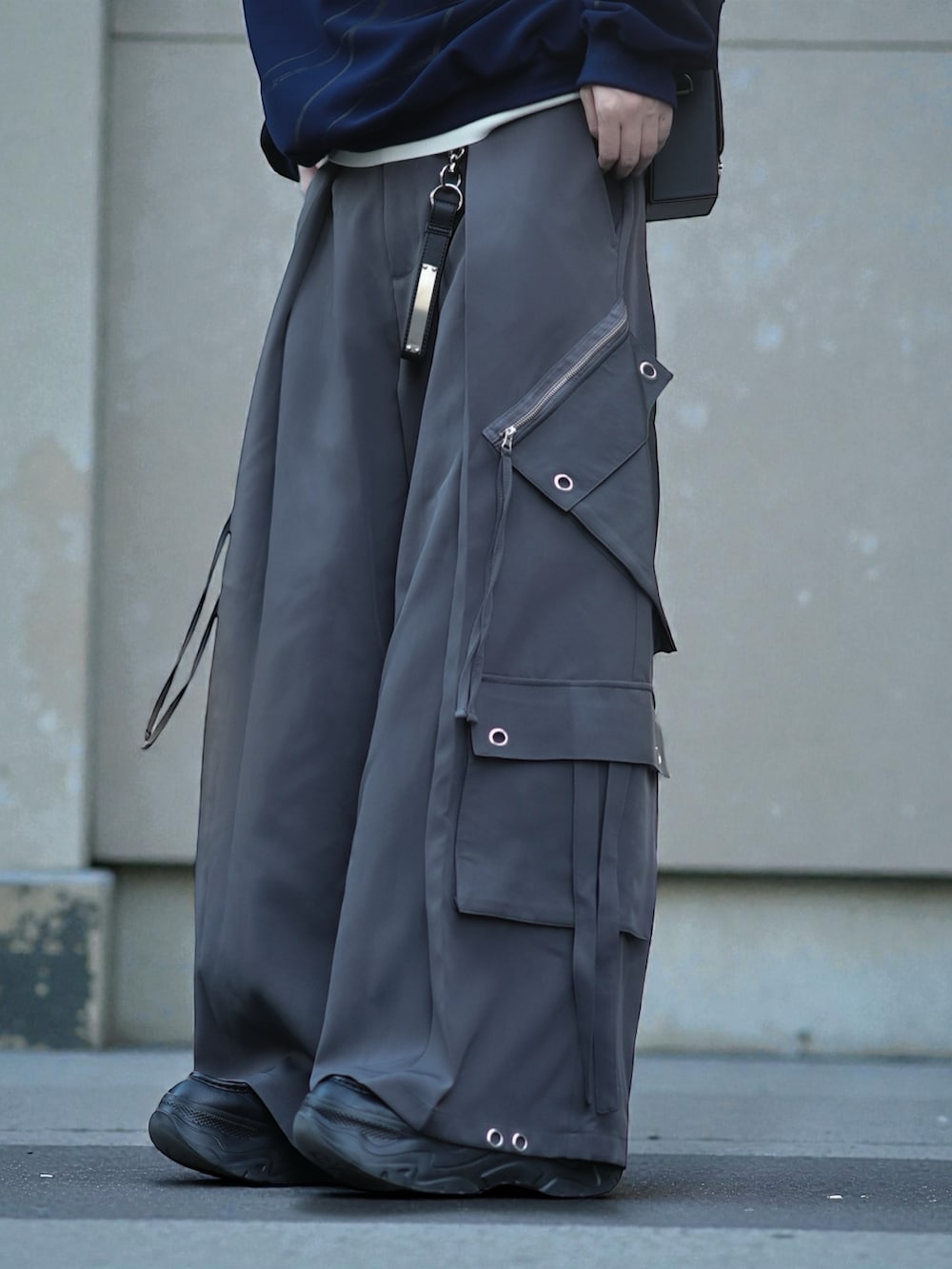 ブルー系のスウェット、ホワイト系のニット/セーター、グレー系のカーゴパンツを着用したメンズの冬コーディネートの3枚目の写真