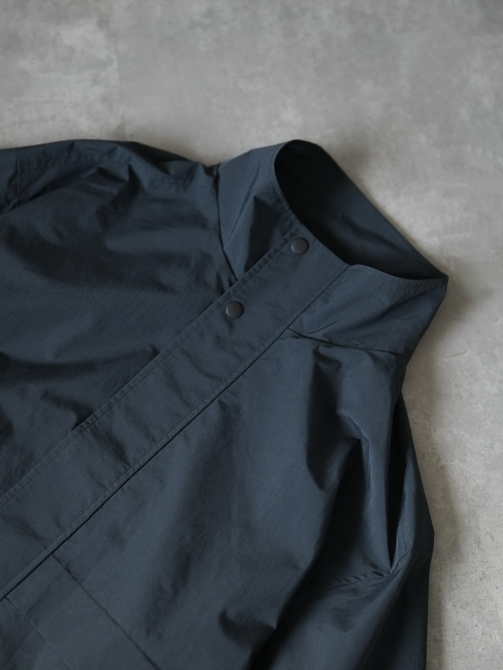 グレー系のスラックス、ブラック系のスニーカー、ホワイト系のスウェットを着用したメンズの冬コーディネートの4枚目の写真