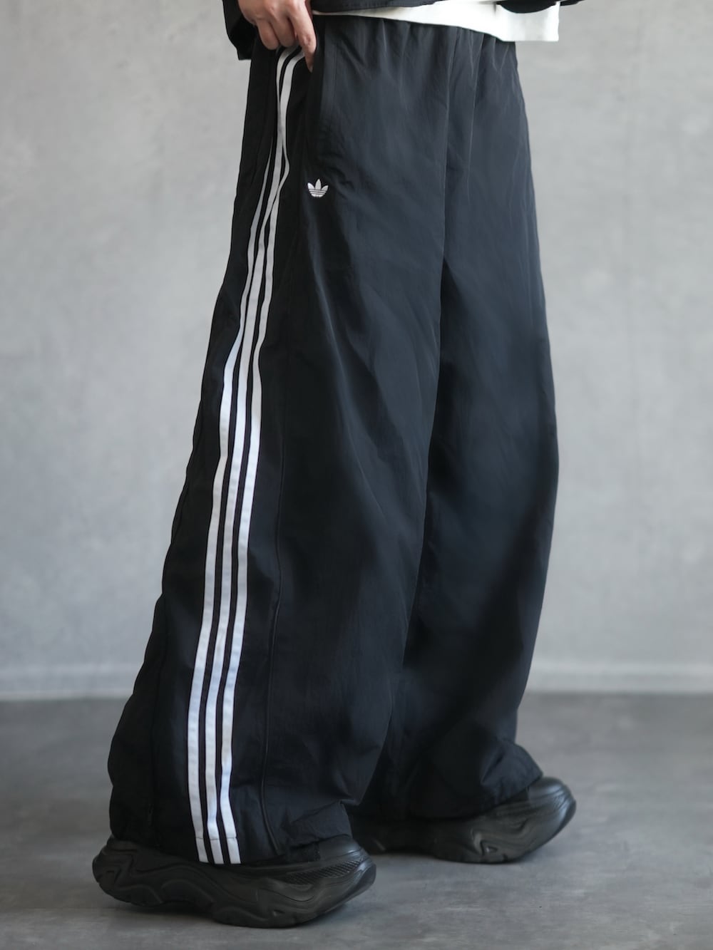 ブラック系のジャケット/アウター、ホワイト系のタンクトップ、ブラック系のスウェットパンツを着用したメンズの春コーディネートの3枚目の写真