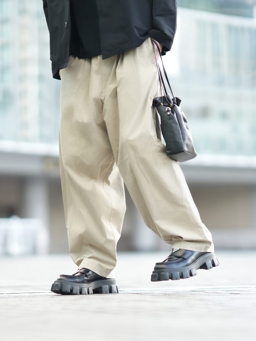 ブラック系のナイロンジャケット、ブラック系のTシャツ/カットソー、ベージュ系のその他パンツを着用したメンズの冬コーディネートの4枚目の写真
