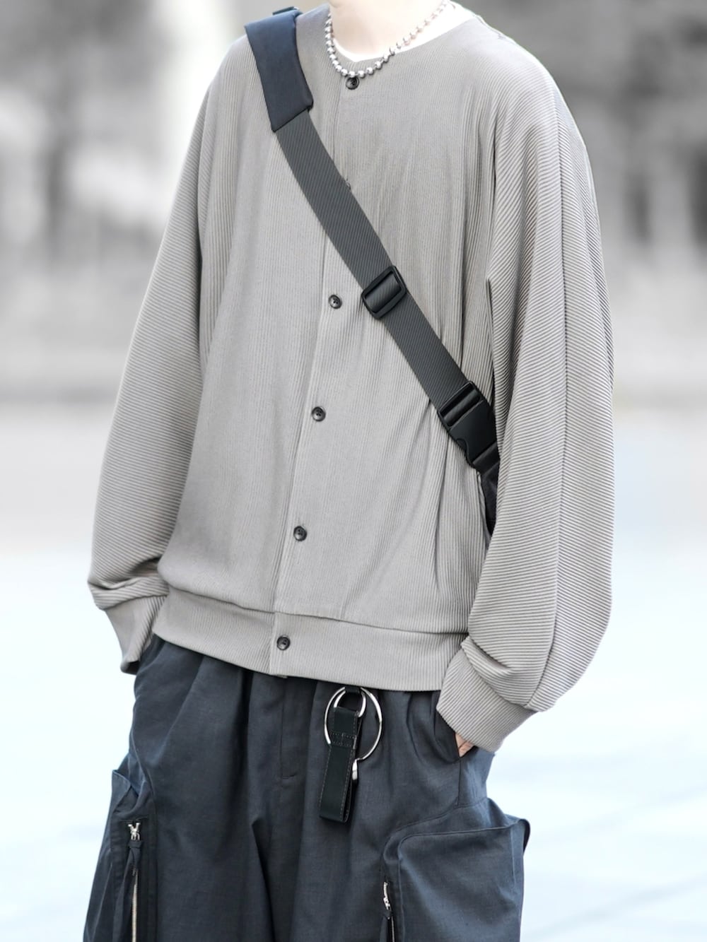 グリーン系のカーディガン/ボレロ、ホワイト系のTシャツ/カットソー、ブラック系のカーゴパンツを着用したメンズの春コーディネートの2枚目の写真
