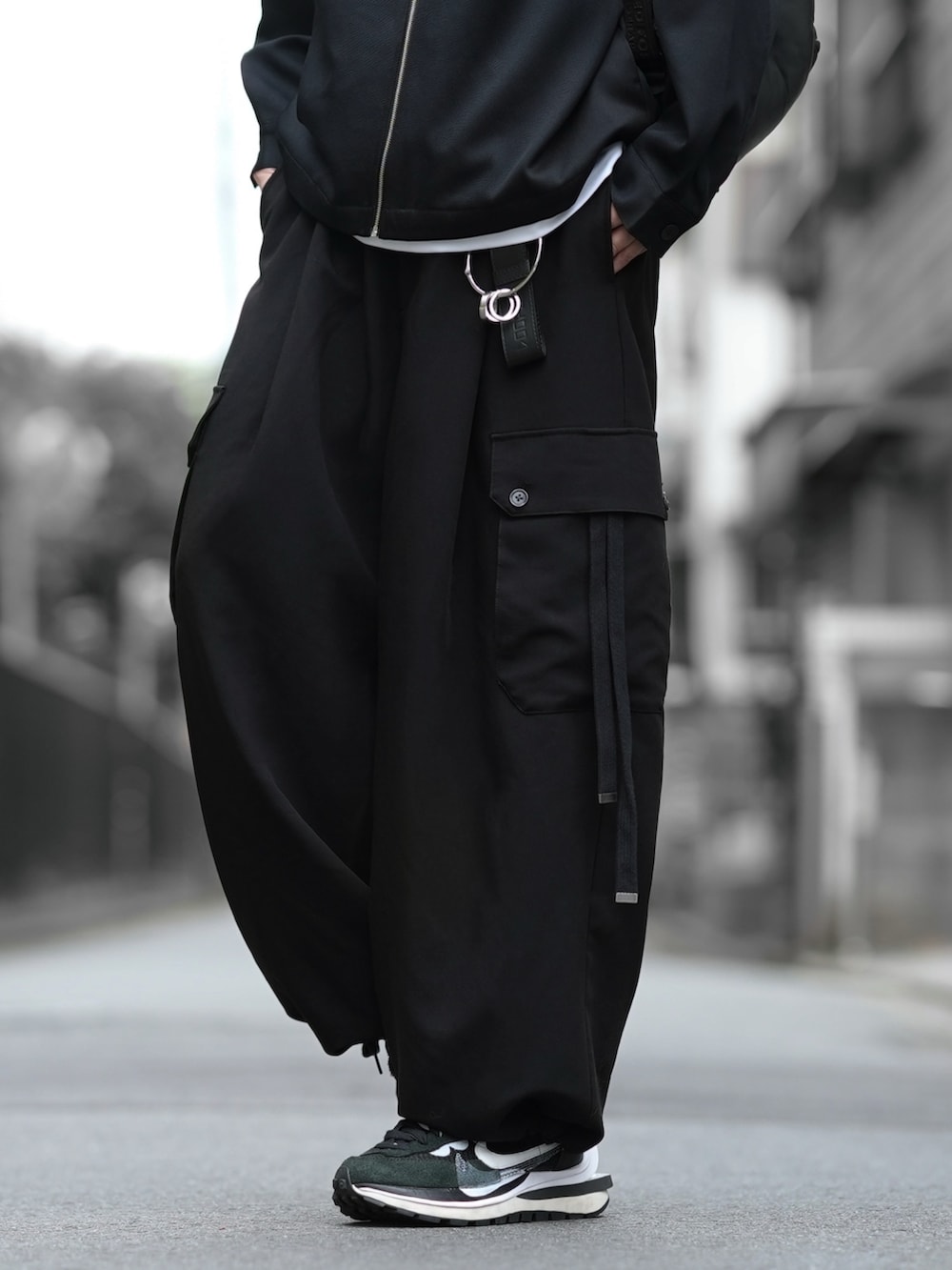 ブラック系のジャケット/アウター、ホワイト系のTシャツ/カットソー、ブラック系のカーゴパンツを着用したメンズの夏コーディネートの5枚目の写真