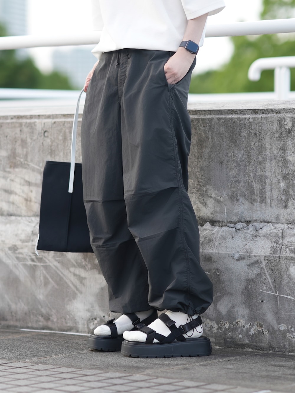 ホワイト系のTシャツ/カットソー、グレー系のカーゴパンツ、ブラック系のサンダルを着用したメンズの夏コーディネートの3枚目の写真