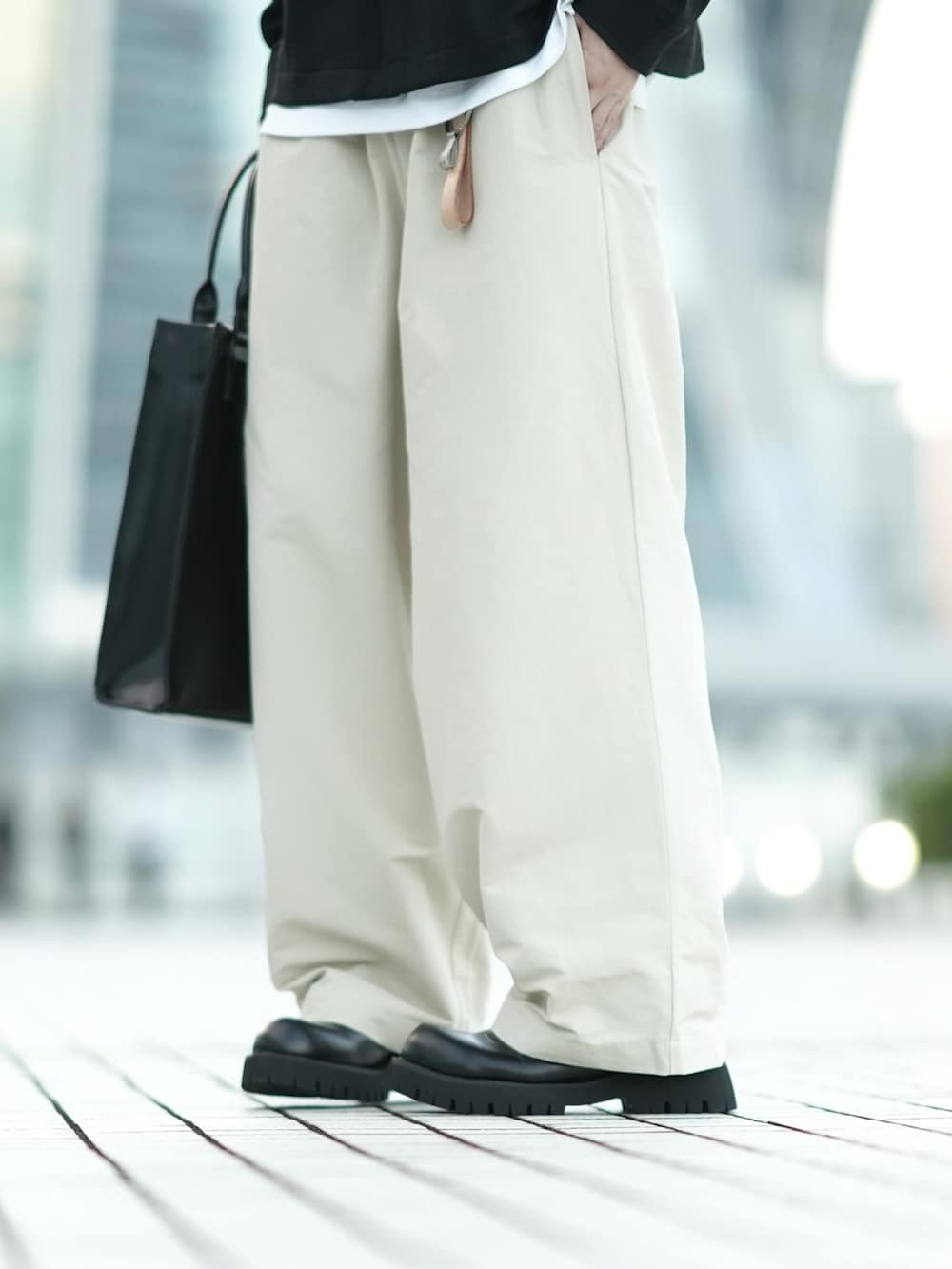 ブラック系のその他アウター、ホワイト系のタンクトップ、グレー系のその他パンツを着用したメンズの秋コーディネートの3枚目の写真