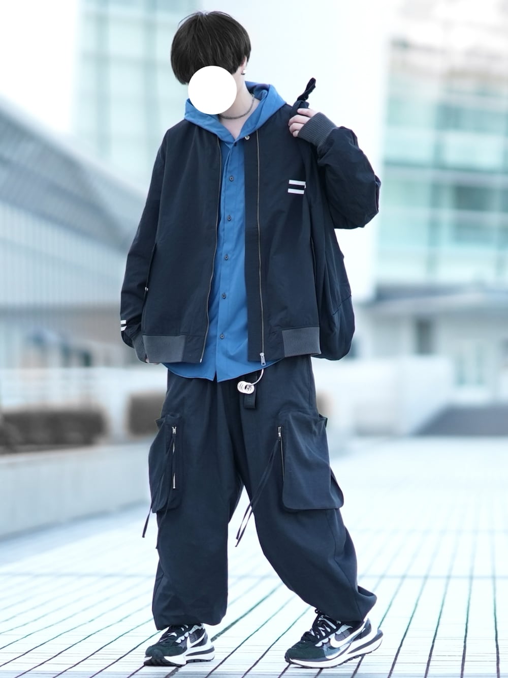 ブラック系のブルゾン、ブルー系のパーカー、ブラック系のカーゴパンツを着用したメンズの冬コーディネートの3枚目の写真