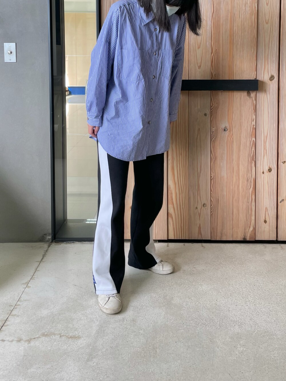 ブラック系のその他パンツ、ブルー系のシャツ/ブラウス、ホワイト系のスニーカーを着用したレディースの冬コーディネートの2枚目の写真