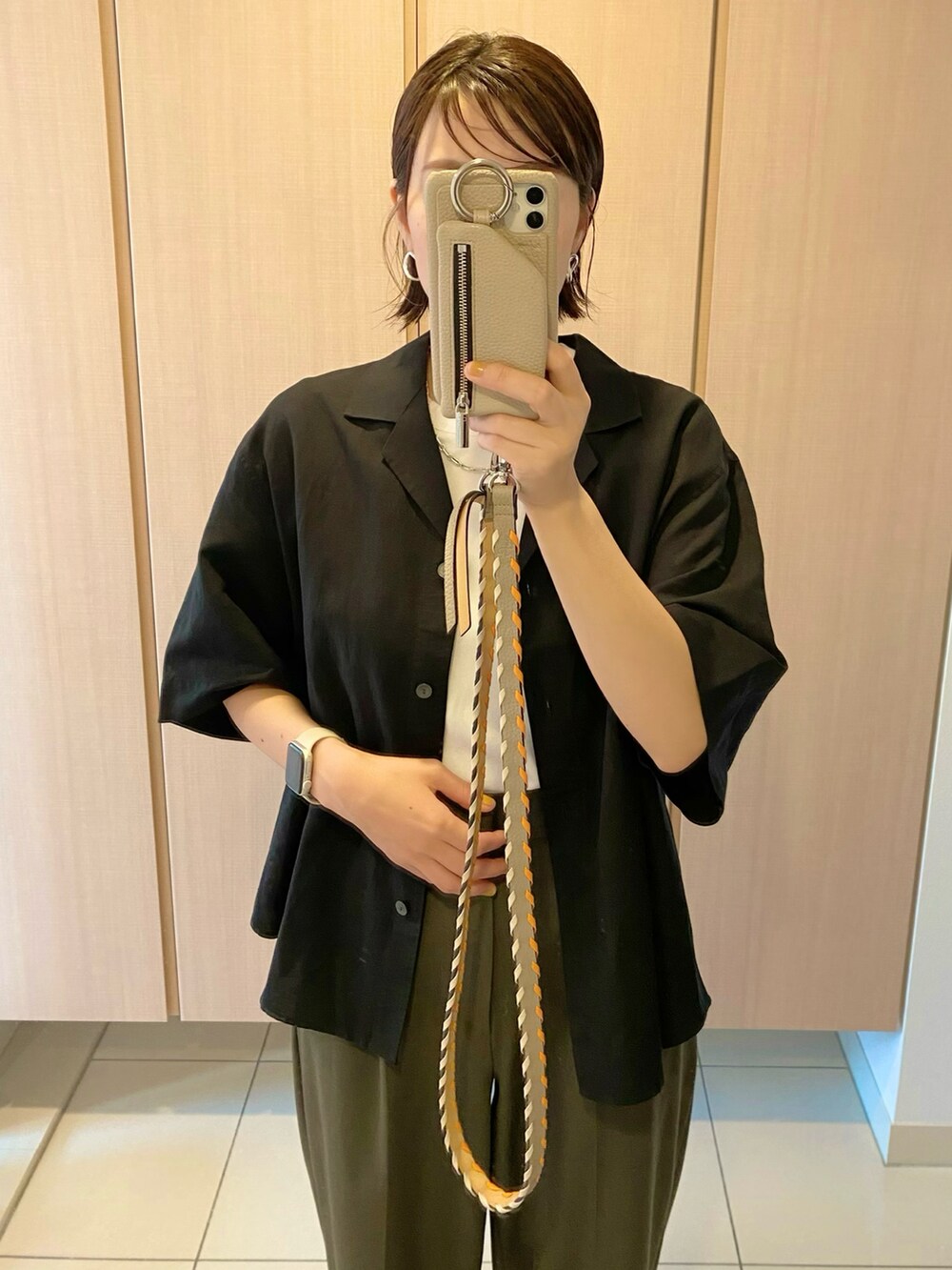 ブラック系のシャツ/ブラウス、ホワイト系のTシャツ/カットソー、グリーン系のパンツを着用したレディースの春コーディネートの2枚目の写真