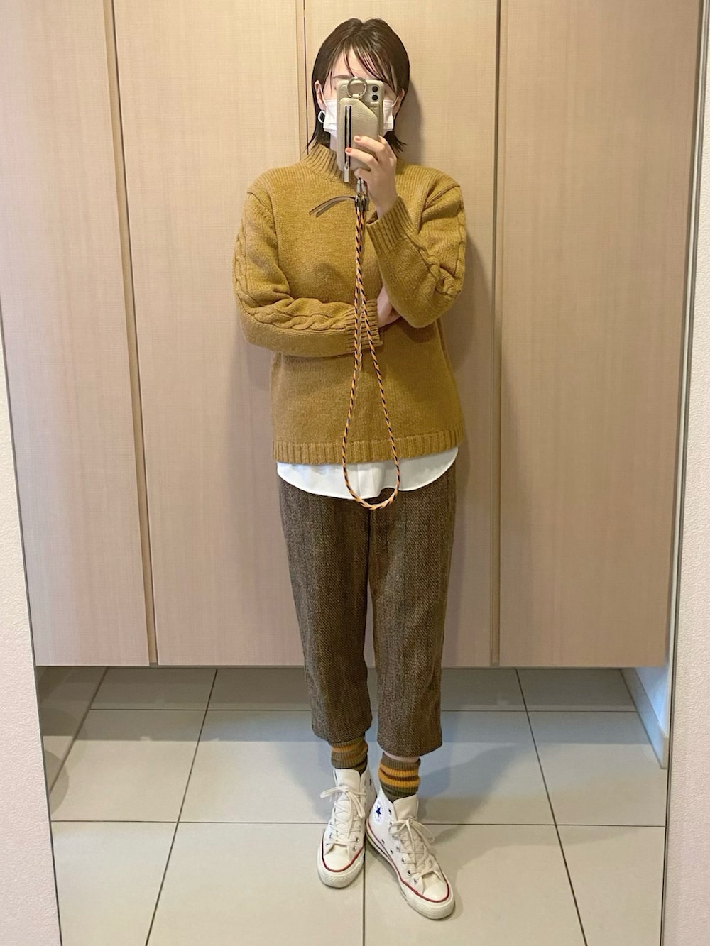 ブラウン系のニット/セーター、ホワイト系のその他アウター、ブラウン系のパンツを着用したレディースの冬コーディネートの2枚目の写真