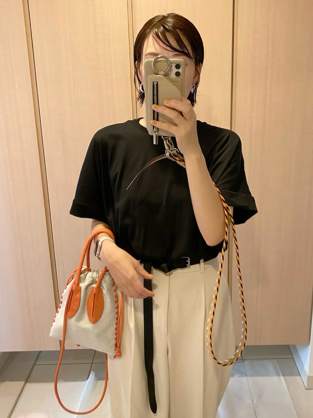 ブラック系のTシャツ/カットソー、ホワイト系のパンツ、ホワイト系のスニーカーを着用したレディースの夏コーディネートの2枚目の写真