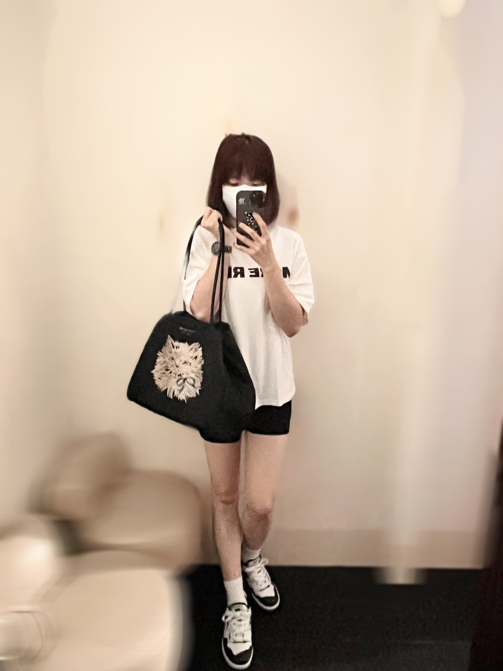 ホワイト系のTシャツ/カットソー、ホワイト系のスニーカー、ブラック系のショルダーバッグを着用したレディースの夏コーディネートの2枚目の写真