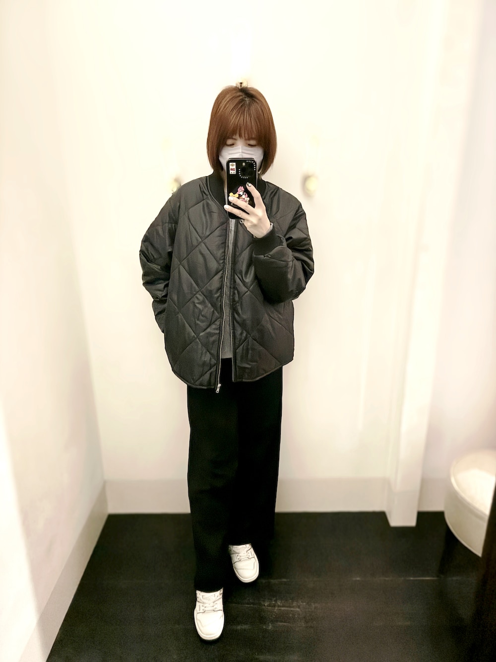 ホワイト系のスニーカー、ブラック系のスラックス、グレー系のニット/セーターを着用したレディースの秋コーディネートの2枚目の写真