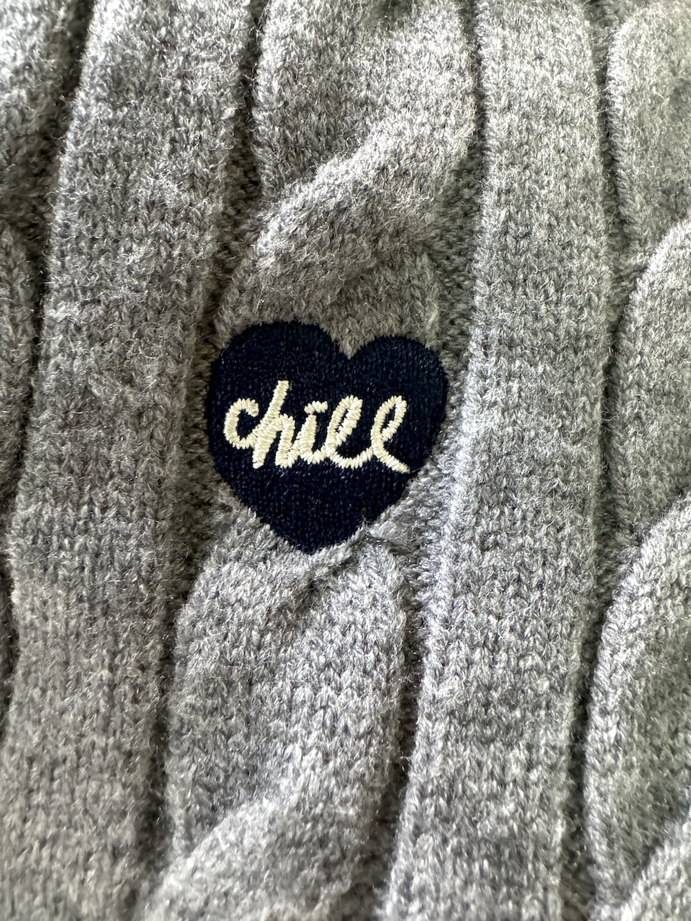 ホワイト系のスニーカー、ブラック系のスラックス、グレー系のニット/セーターを着用したレディースの秋コーディネートの3枚目の写真