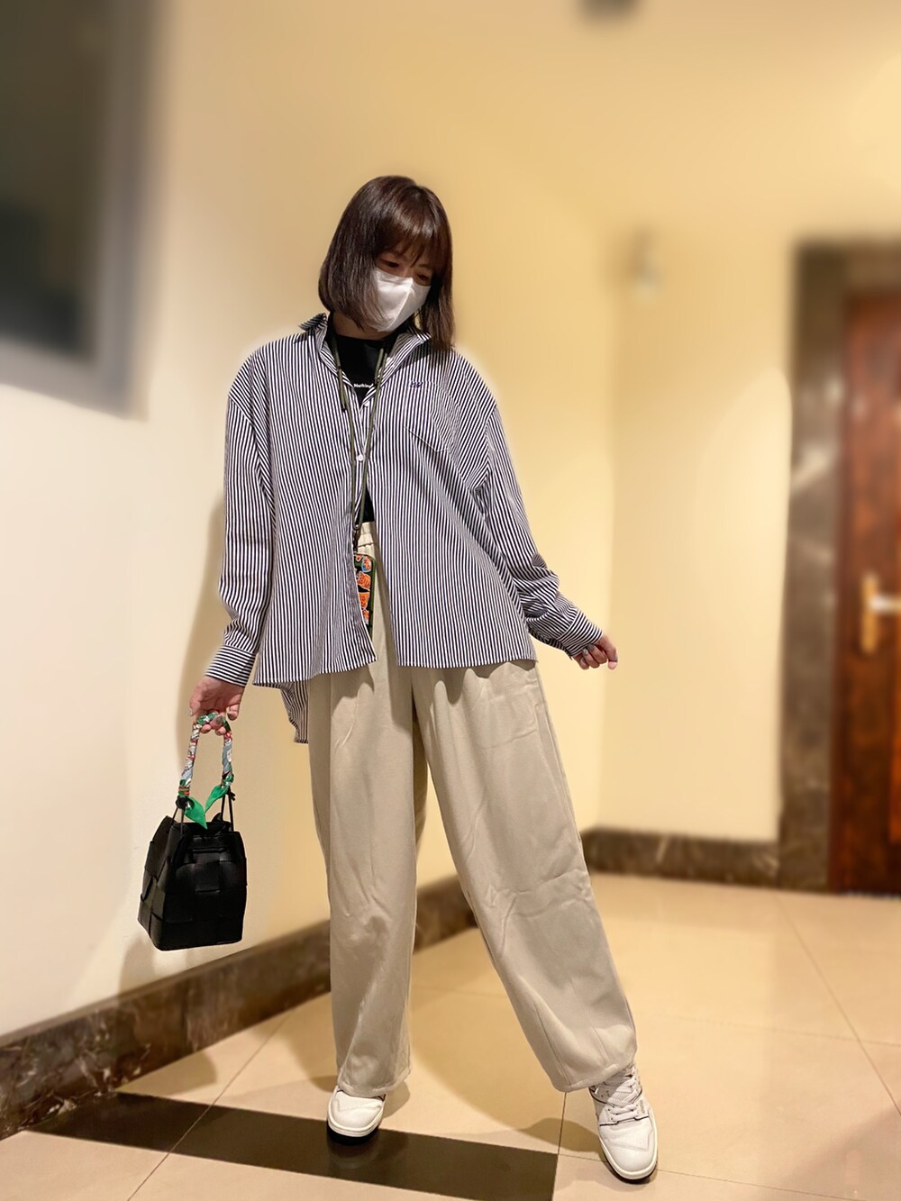 ブルー系のシャツ/ブラウス、ベージュ系のパンツ、ホワイト系のスニーカーを着用したレディースの秋コーディネートの3枚目の写真