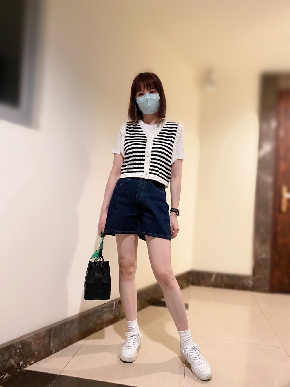 その他のベスト、ブルー系のデニムパンツ、ブラック系のバッグを着用したレディースの秋コーディネートの2枚目の写真