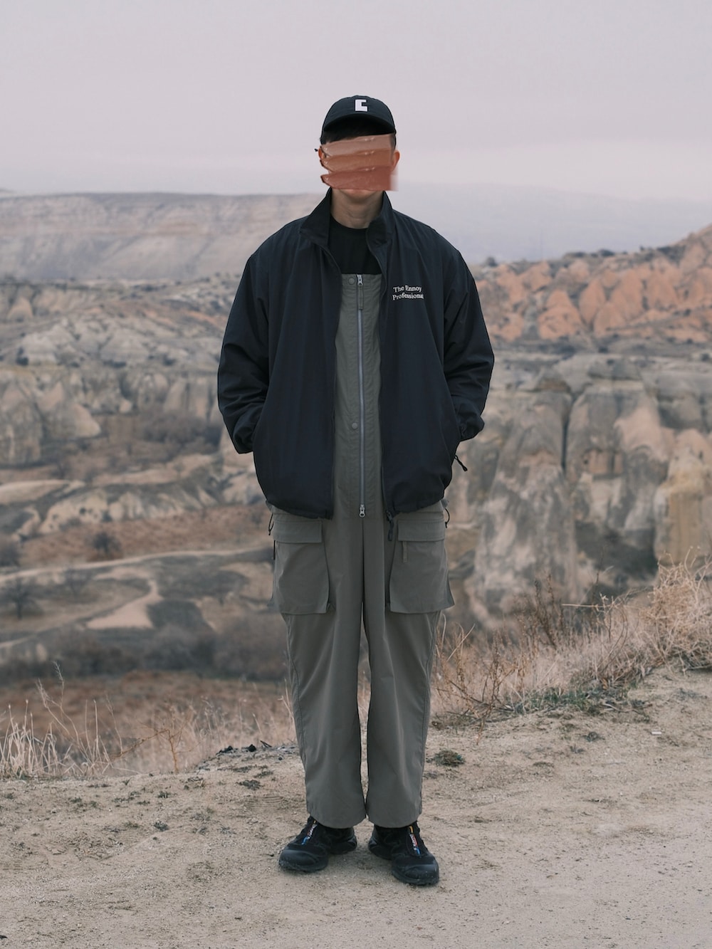 ブラック系のナイロンジャケット、グリーン系のサロペット/オーバーオール、ブラック系のスニーカーを着用したメンズの冬コーディネートの3枚目の写真