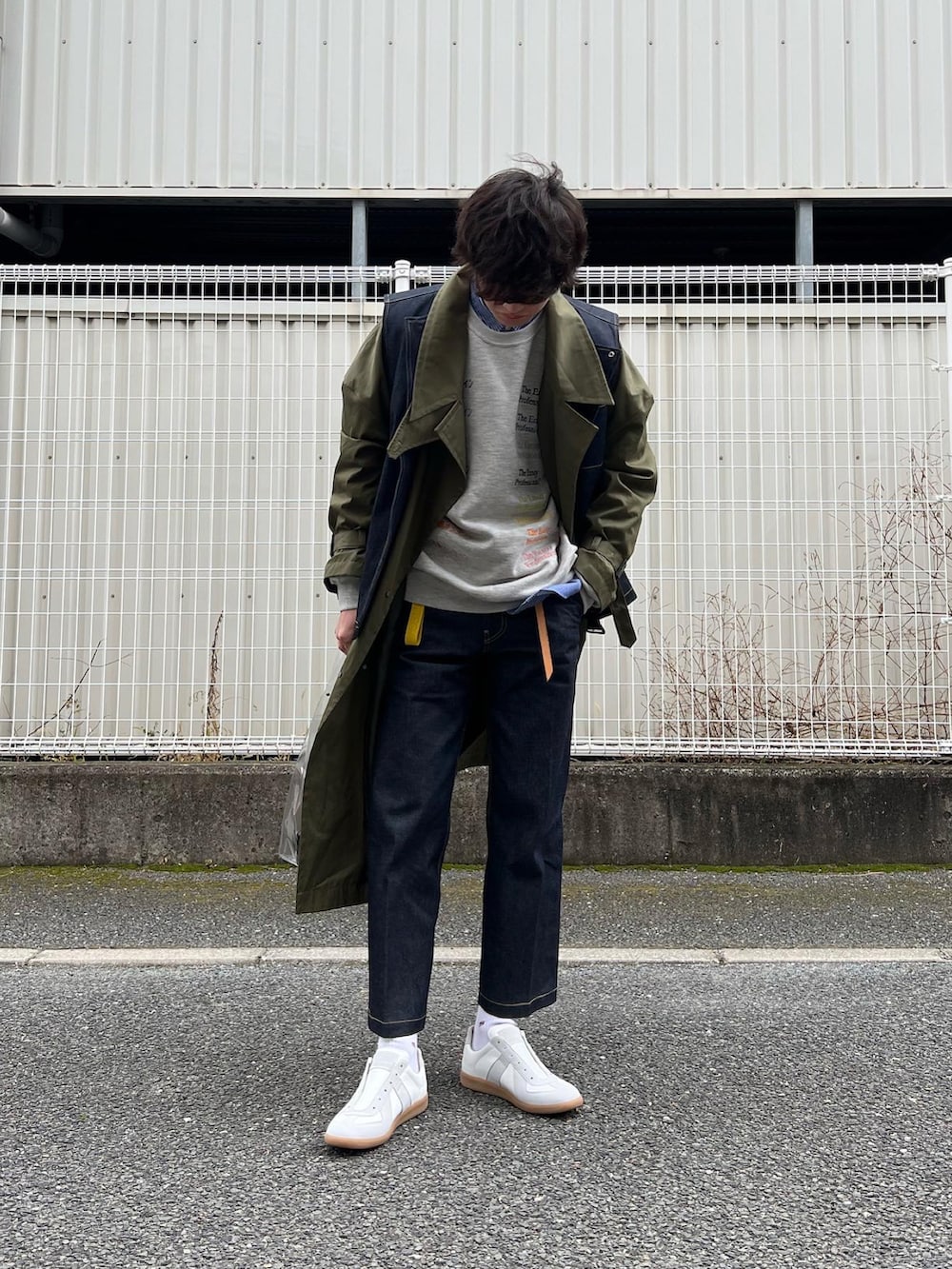 「春服みてみて、デニムパンツ、ミリタリー、ミリタリーコーデ、デニムベスト、デニムスラックス、ジャーマントレーナー、レイヤードスタイル、クリアバッグ、PVC、RYOTAKASHIMA、ennoy、カーキアウター、ベスト、ロングコート」｜「Maison Margielaの＜MAISON MARGIELA（メゾン マルジェラ）＞ REPLICA LOW■■■（スニーカー、ホワイト系）」を使った、natsukiさん（メンズ・187cm）の春コーディネートの3枚目の写真