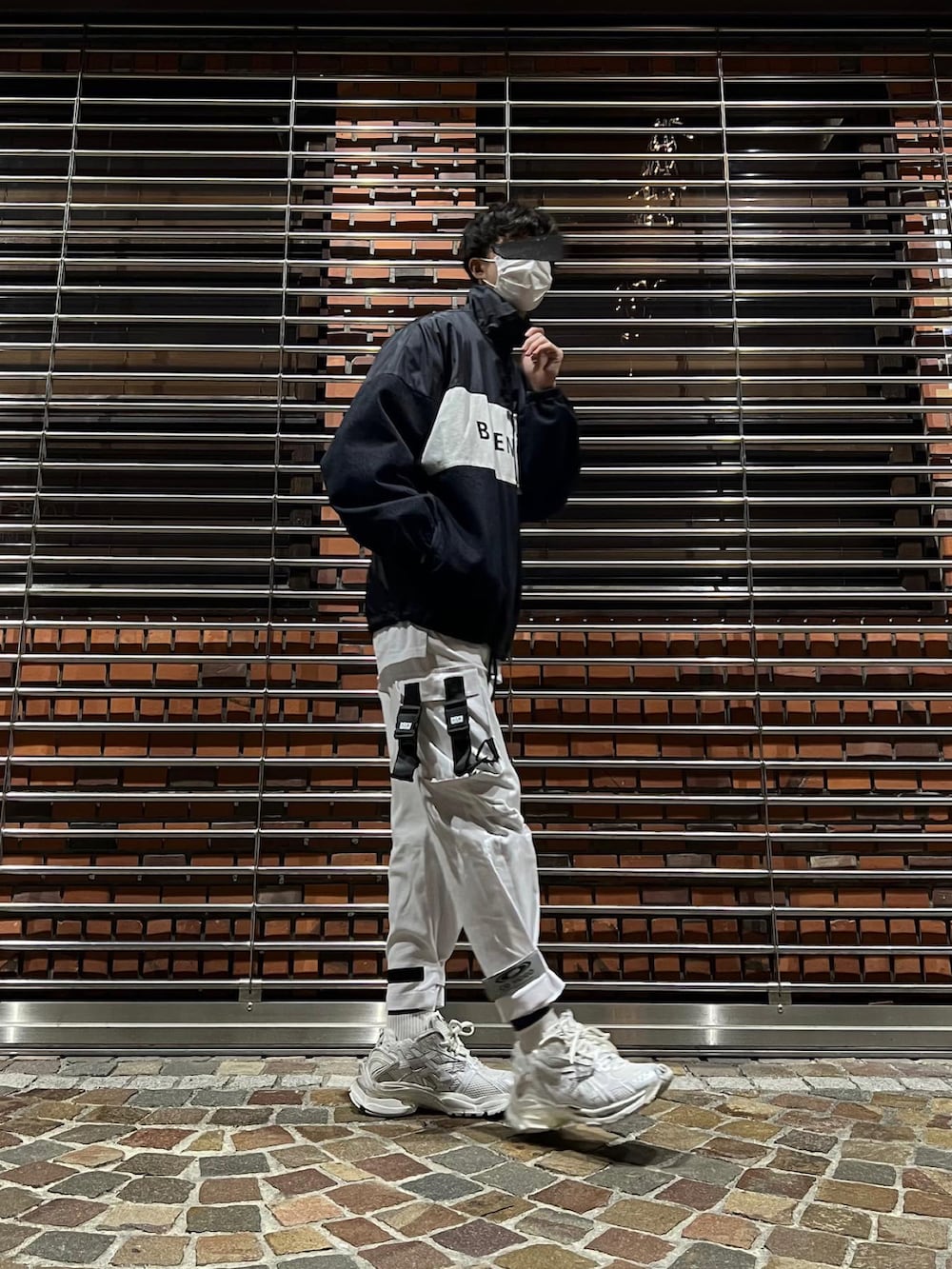 ホワイト系のスニーカー、ホワイト系のカーゴパンツ、ブラック系のナイロンジャケットを着用したメンズの冬コーディネートの4枚目の写真