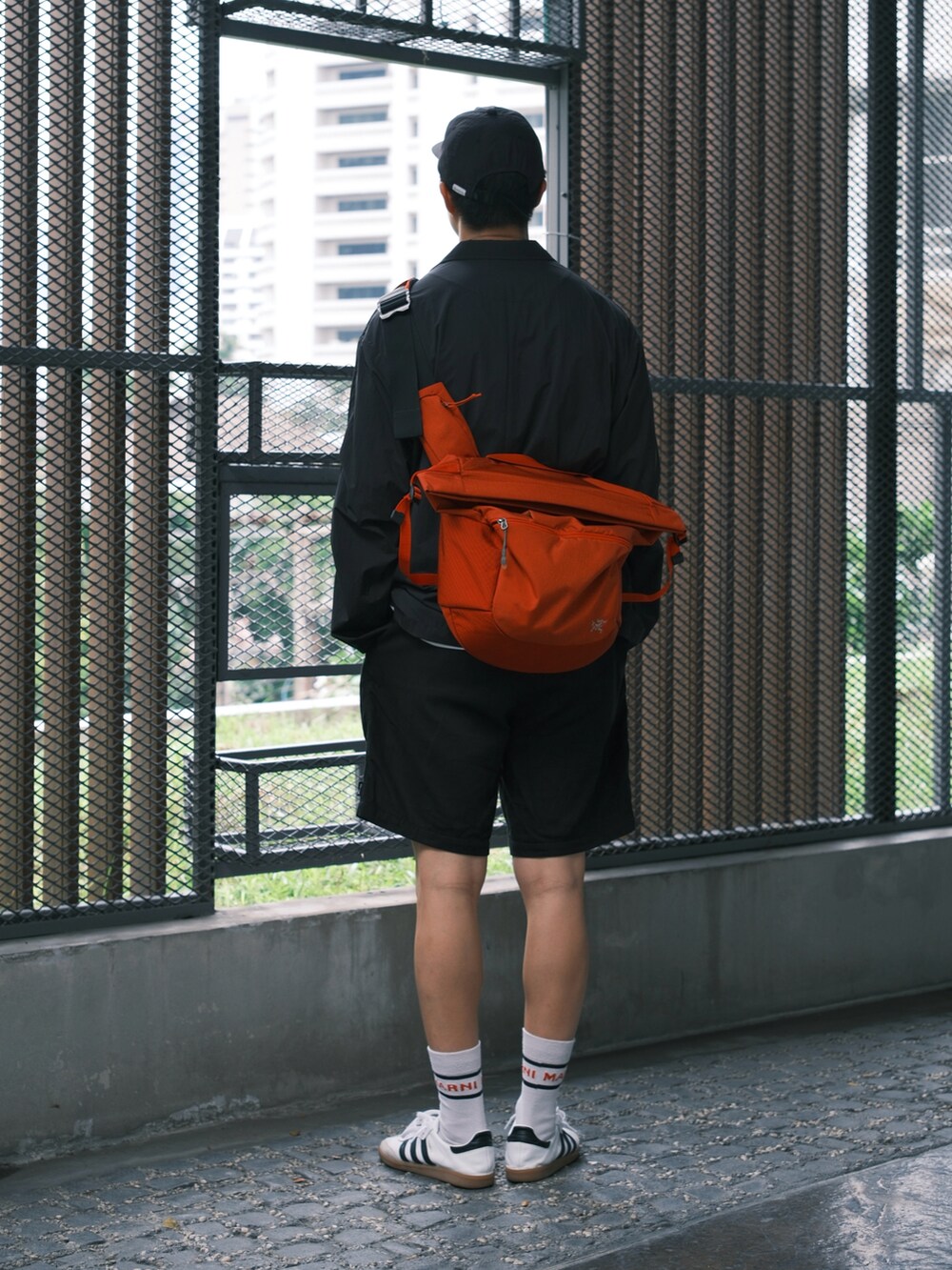 ホワイト系のスニーカー、ブラック系のその他パンツ、ブラック系のその他アウターを着用したメンズの春コーディネートの4枚目の写真