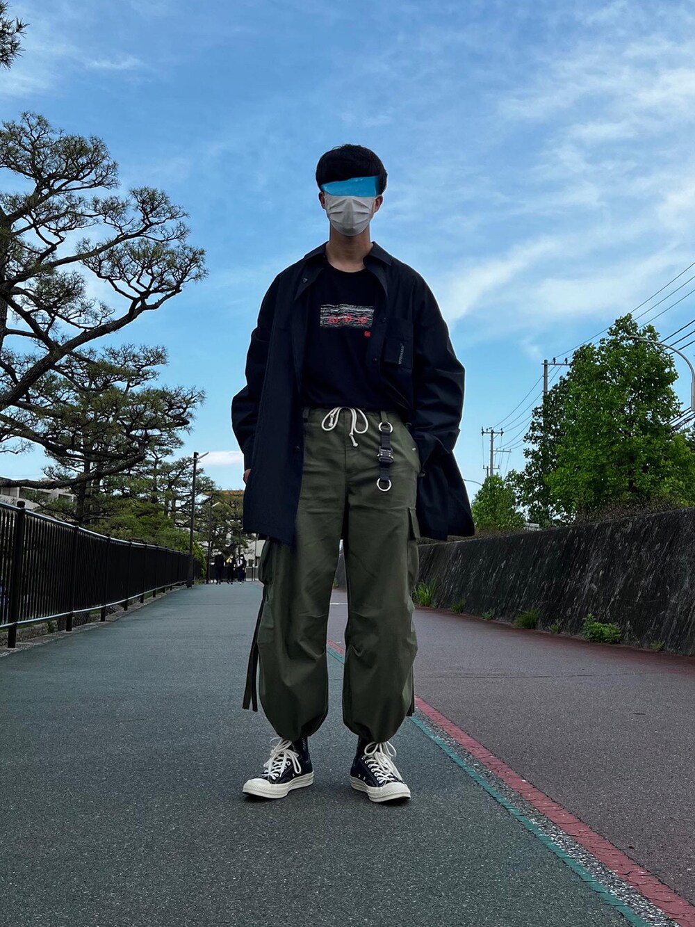 ブラック系のスニーカー、グリーン系のカーゴパンツ、ブラック系のTシャツ/カットソーを着用したメンズの夏コーディネートの2枚目の写真