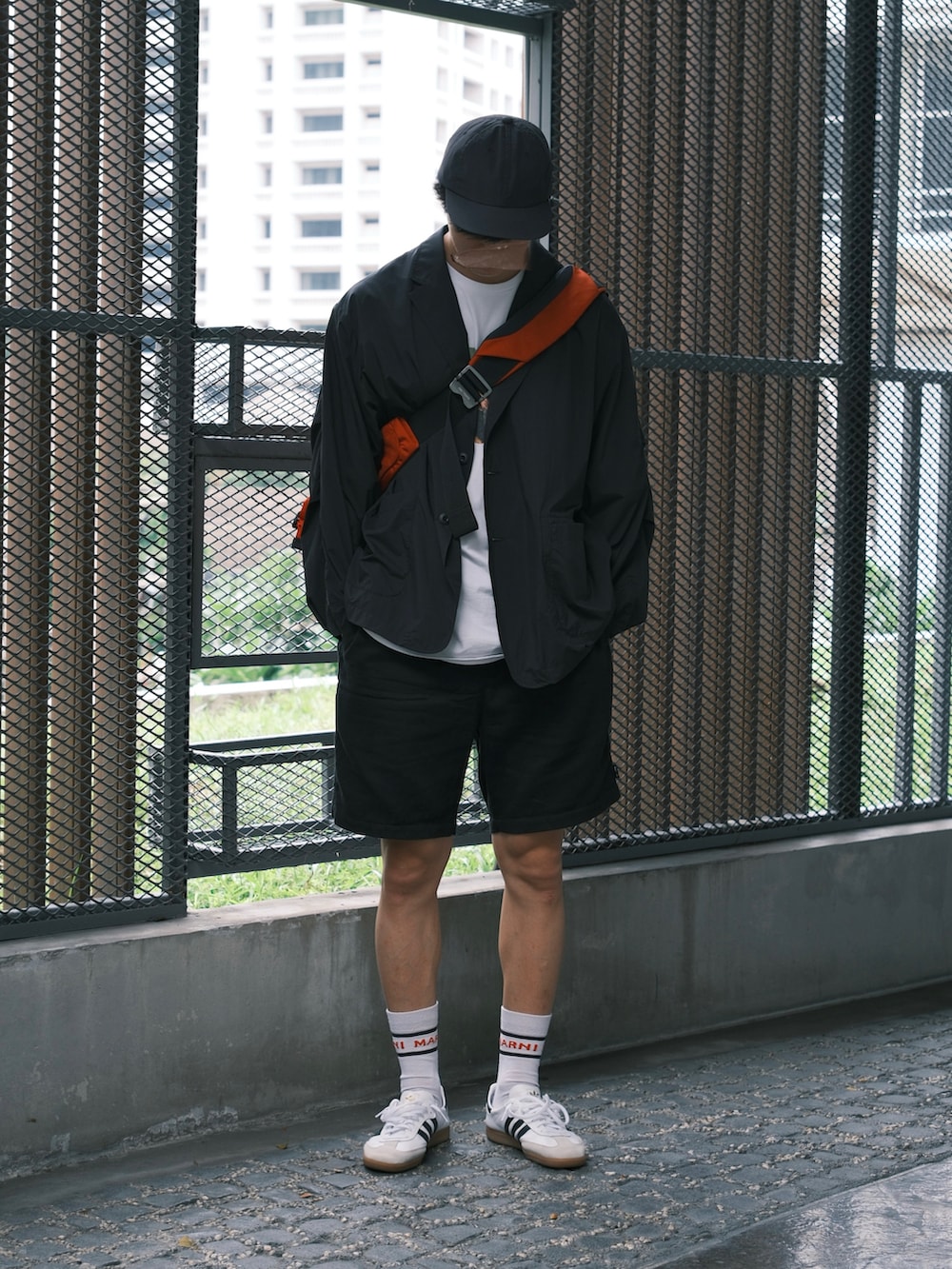 ホワイト系のスニーカー、ブラック系のその他パンツ、ブラック系のその他アウターを着用したメンズの春コーディネートの2枚目の写真