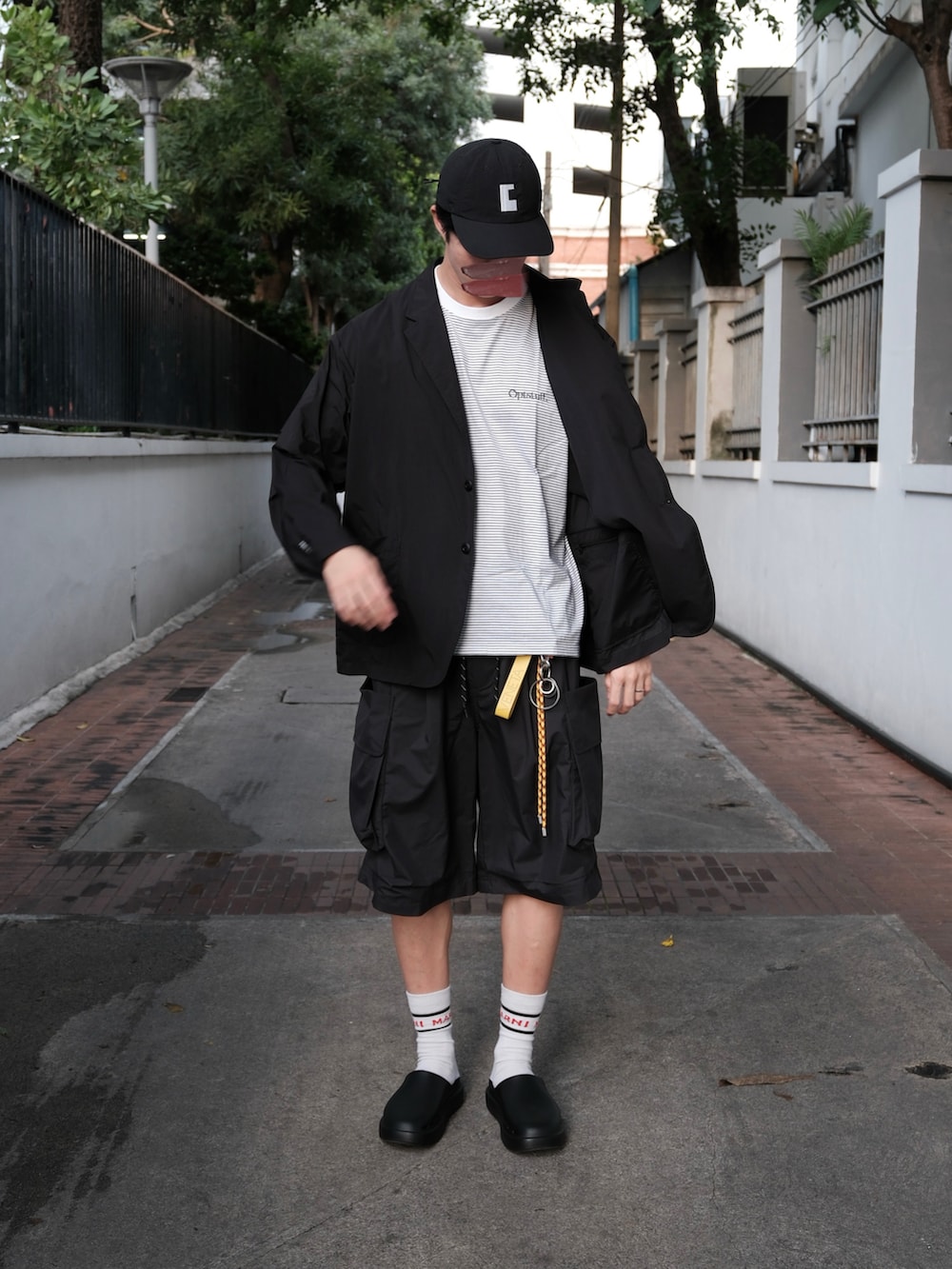 ブラック系のその他アウター、ホワイト系のTシャツ/カットソー、ブラック系のパンツを着用したメンズの秋コーディネートの2枚目の写真