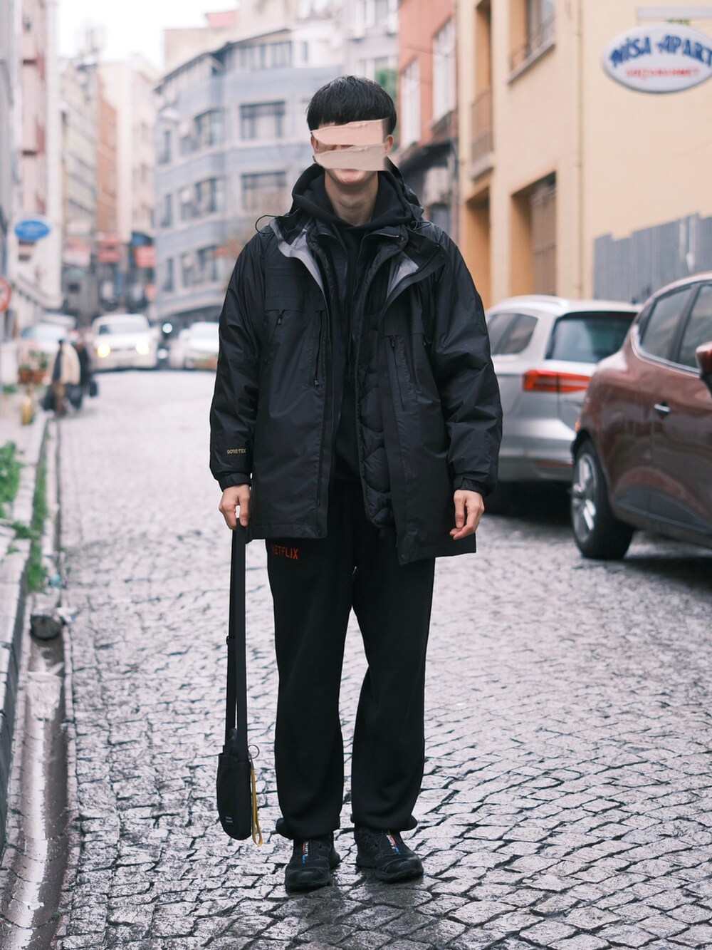 ブラック系のスニーカー、ブラック系のスウェットパンツ、ブラック系のマウンテンパーカーを着用したメンズの冬コーディネートの2枚目の写真