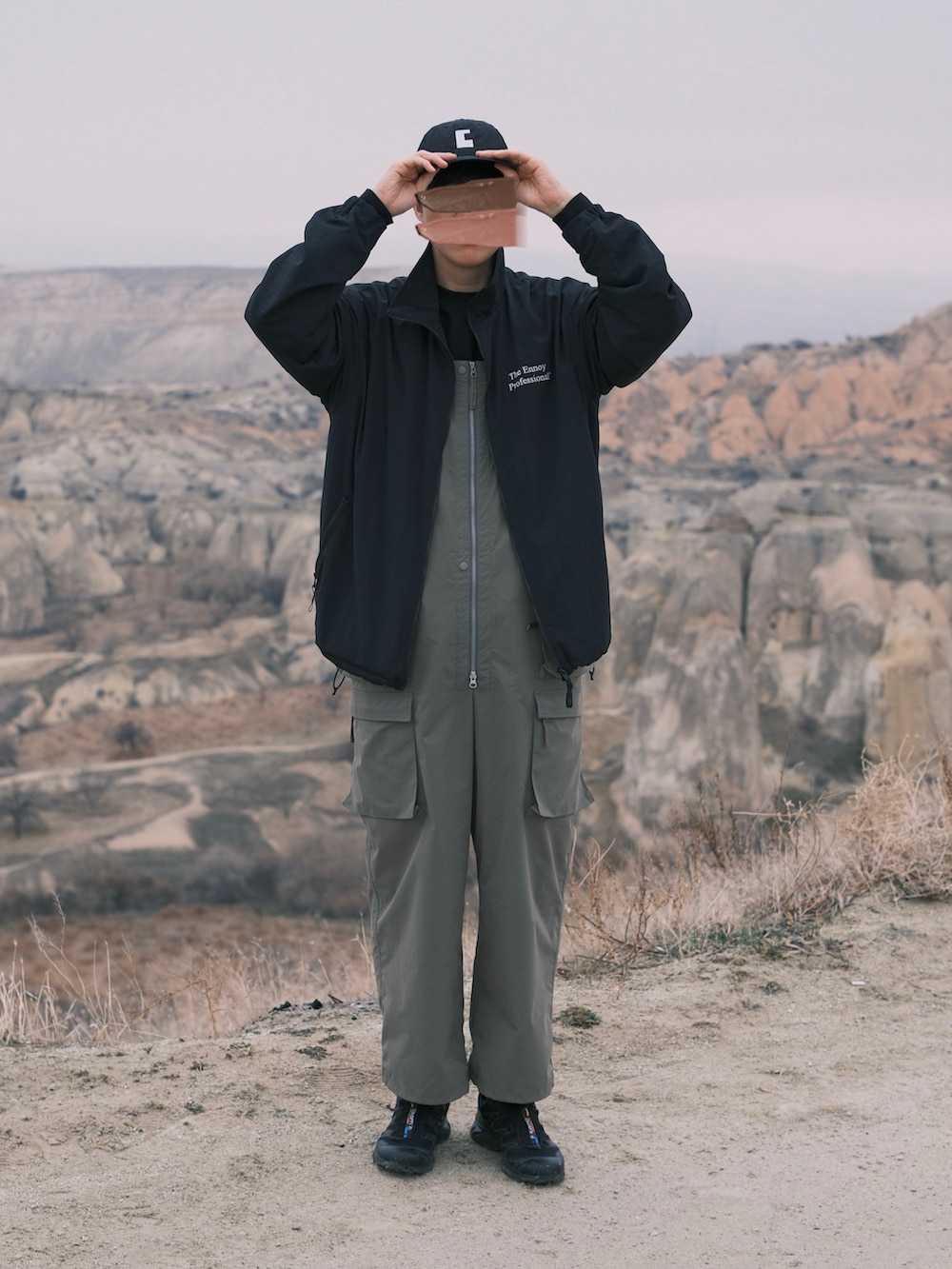 ブラック系のナイロンジャケット、グリーン系のサロペット/オーバーオール、ブラック系のスニーカーを着用したメンズの冬コーディネートの4枚目の写真