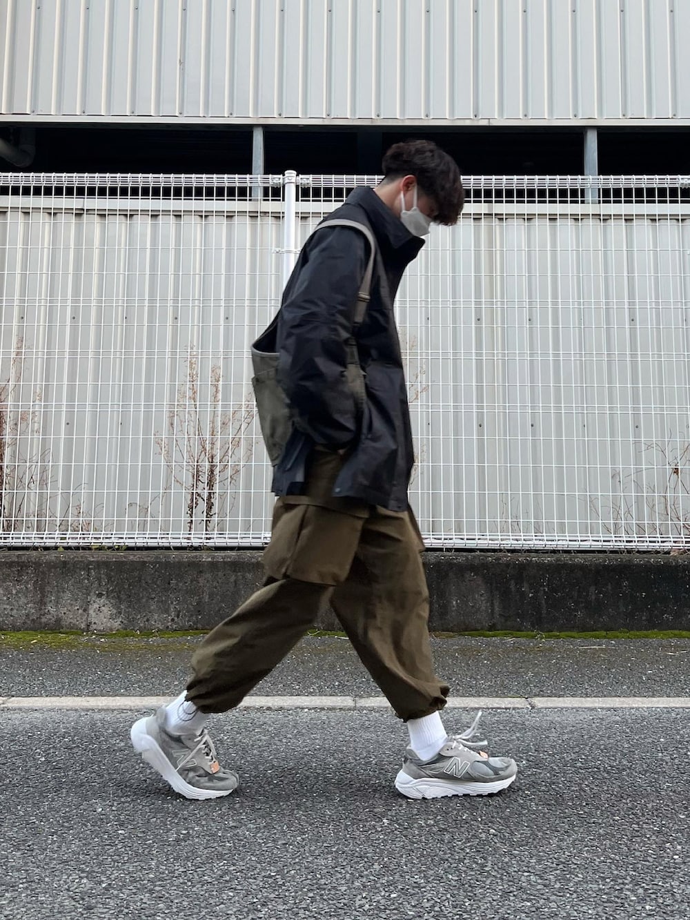 グレー系のスニーカー、グリーン系のその他パンツ、ブラック系のマウンテンパーカーを着用したメンズの冬コーディネートの4枚目の写真
