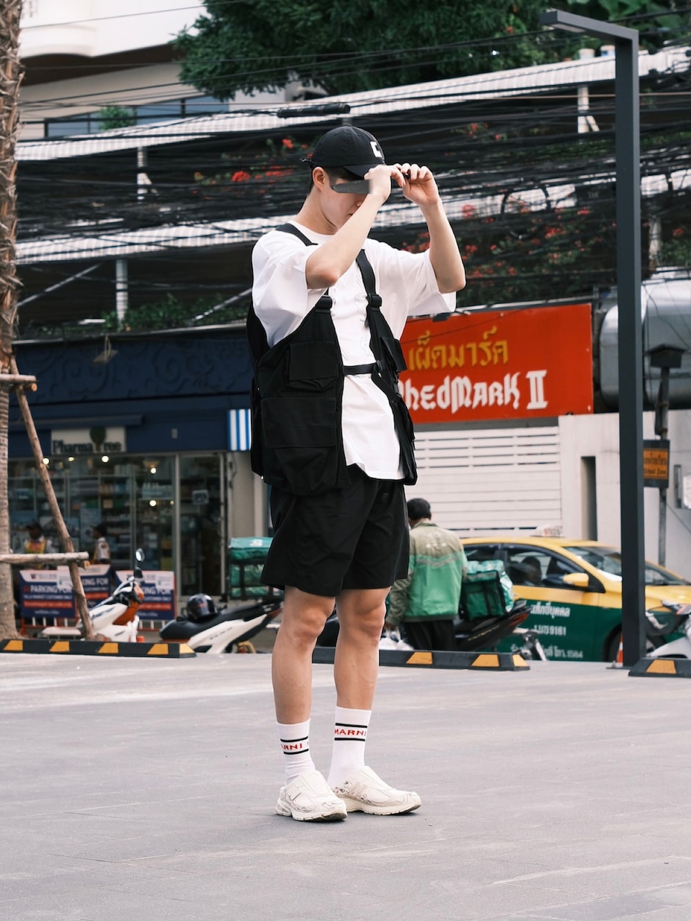 ホワイト系のTシャツ/カットソー、ブラック系のベスト、ブラック系のその他パンツを着用したメンズの夏コーディネートの4枚目の写真