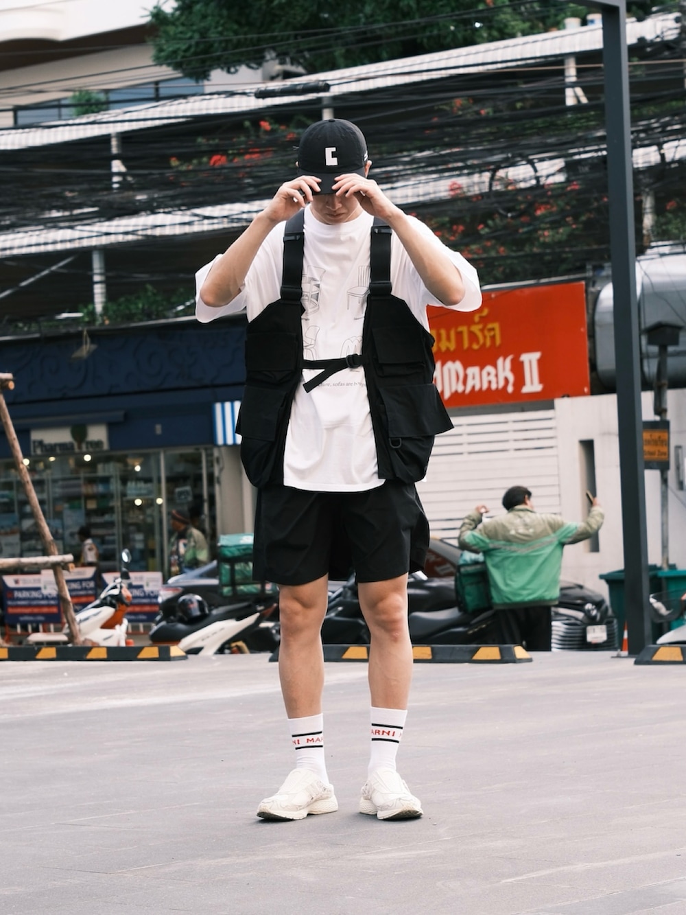 ホワイト系のTシャツ/カットソー、ブラック系のベスト、ブラック系のその他パンツを着用したメンズの夏コーディネートの2枚目の写真