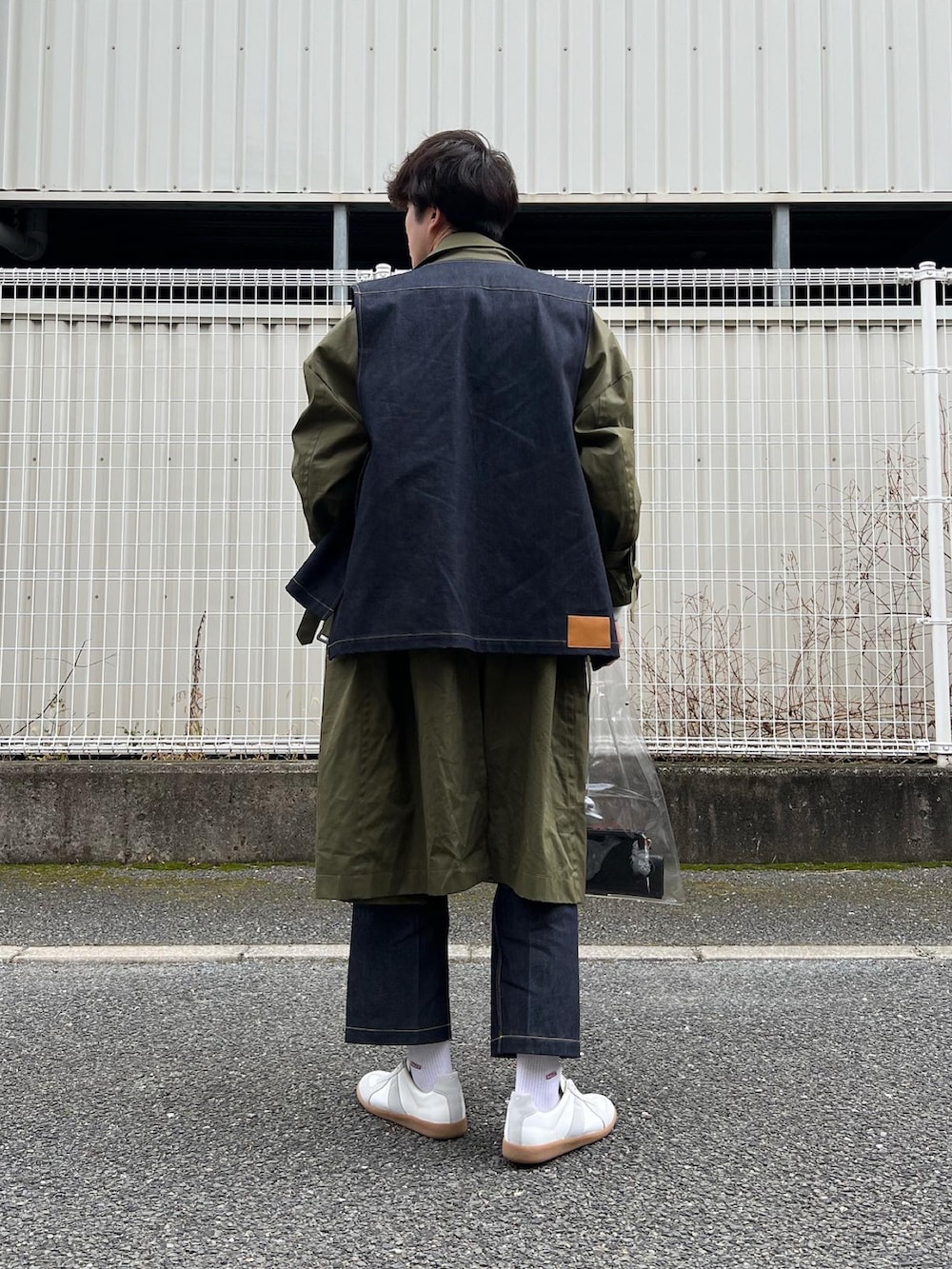 「春服みてみて、デニムパンツ、ミリタリー、ミリタリーコーデ、デニムベスト、デニムスラックス、ジャーマントレーナー、レイヤードスタイル、クリアバッグ、PVC、RYOTAKASHIMA、ennoy、カーキアウター、ベスト、ロングコート」｜「Maison Margielaの＜MAISON MARGIELA（メゾン マルジェラ）＞ REPLICA LOW■■■（スニーカー、ホワイト系）」を使った、natsukiさん（メンズ・187cm）の春コーディネートの5枚目の写真