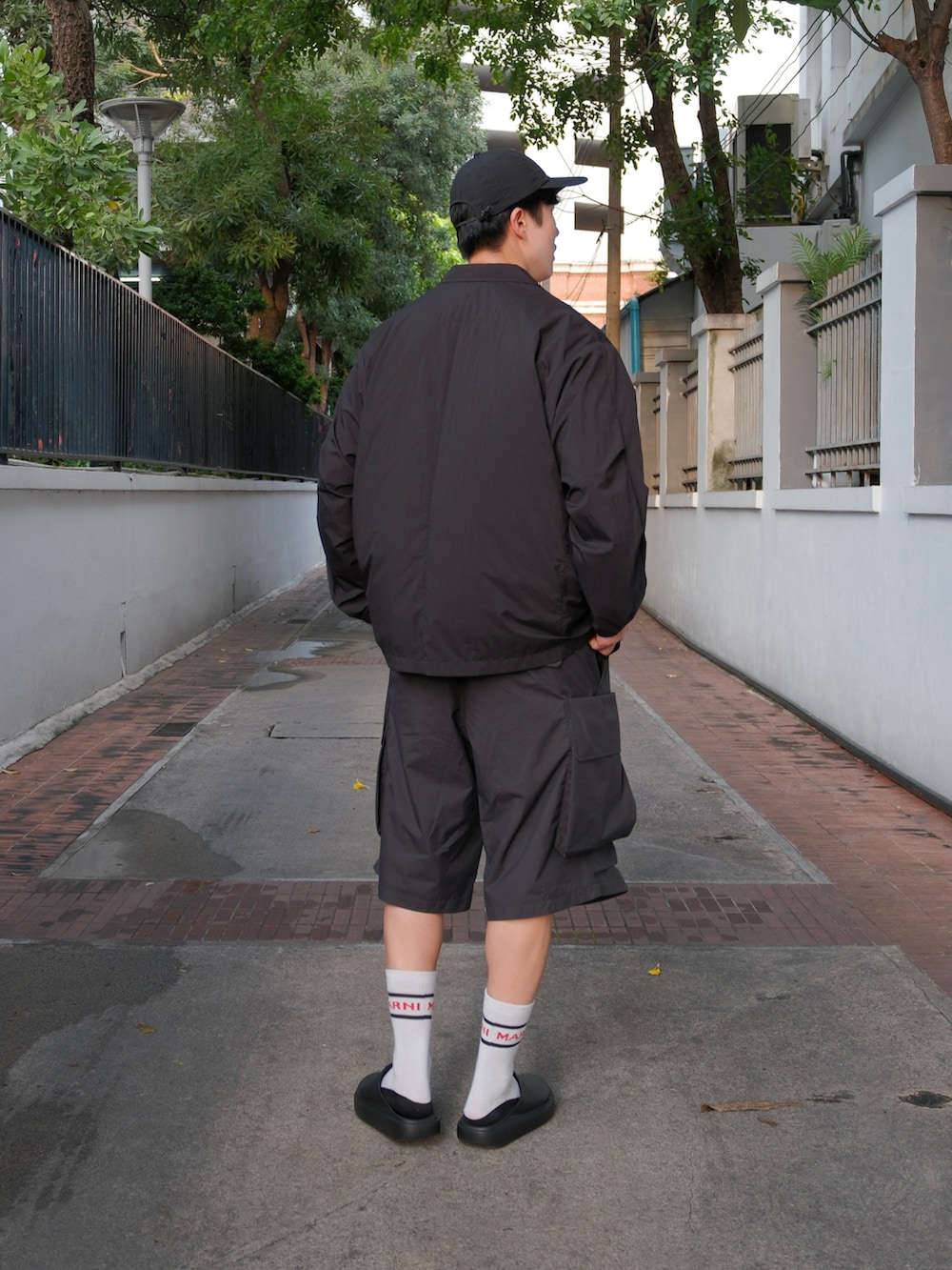 ブラック系のその他アウター、ホワイト系のTシャツ/カットソー、ブラック系のパンツを着用したメンズの秋コーディネートの4枚目の写真