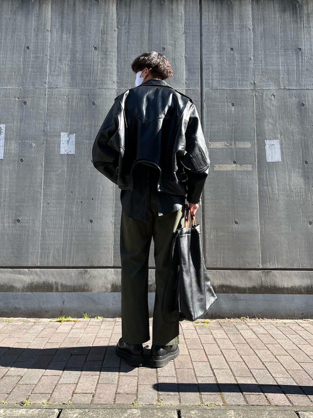 ブラック系のブーツ、ブラック系のトートバッグ、グリーン系のチノパンツを着用したメンズの冬コーディネートの5枚目の写真