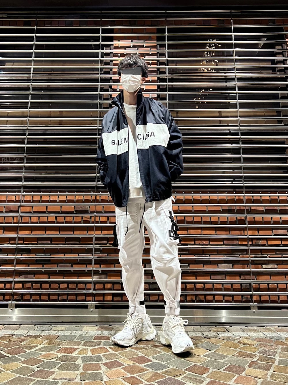 ホワイト系のスニーカー、ホワイト系のカーゴパンツ、ブラック系のナイロンジャケットを着用したメンズの冬コーディネートの5枚目の写真