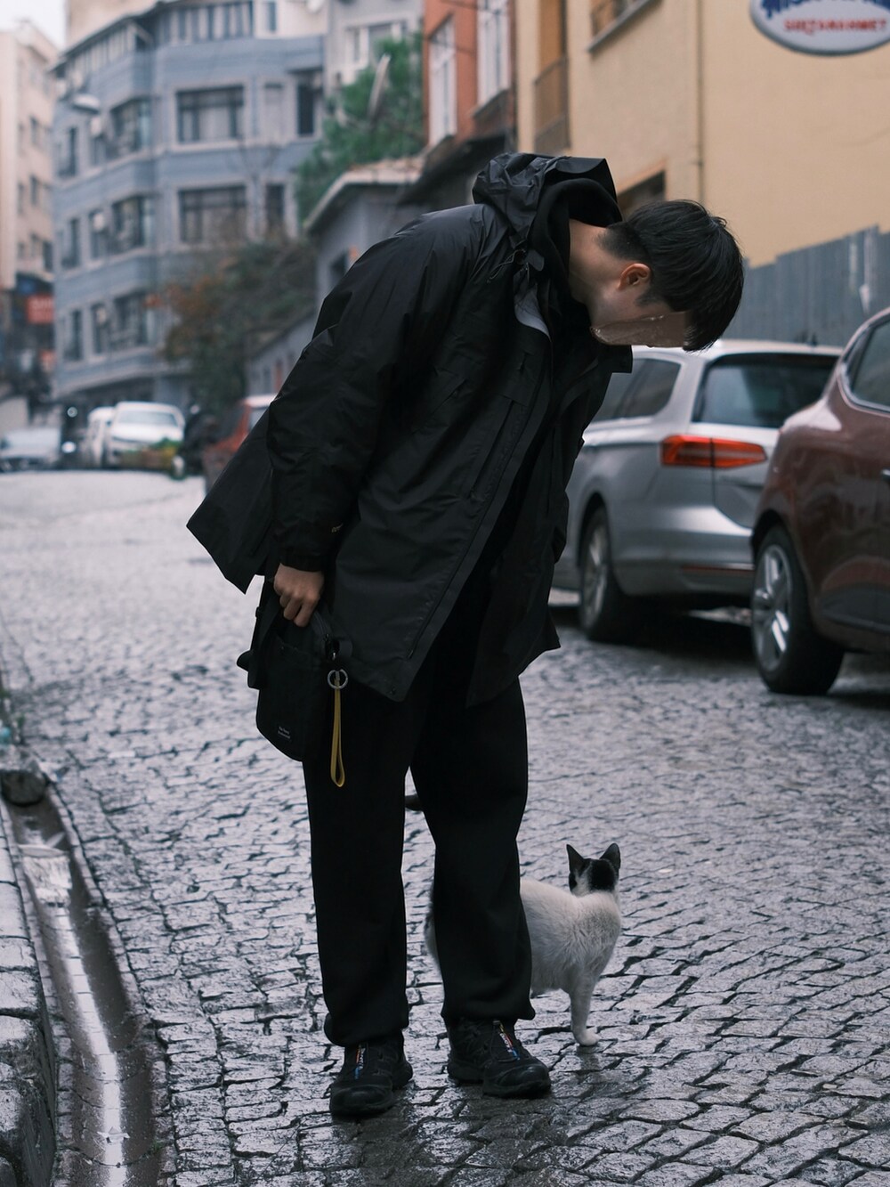 ブラック系のスニーカー、ブラック系のスウェットパンツ、ブラック系のマウンテンパーカーを着用したメンズの冬コーディネートの4枚目の写真