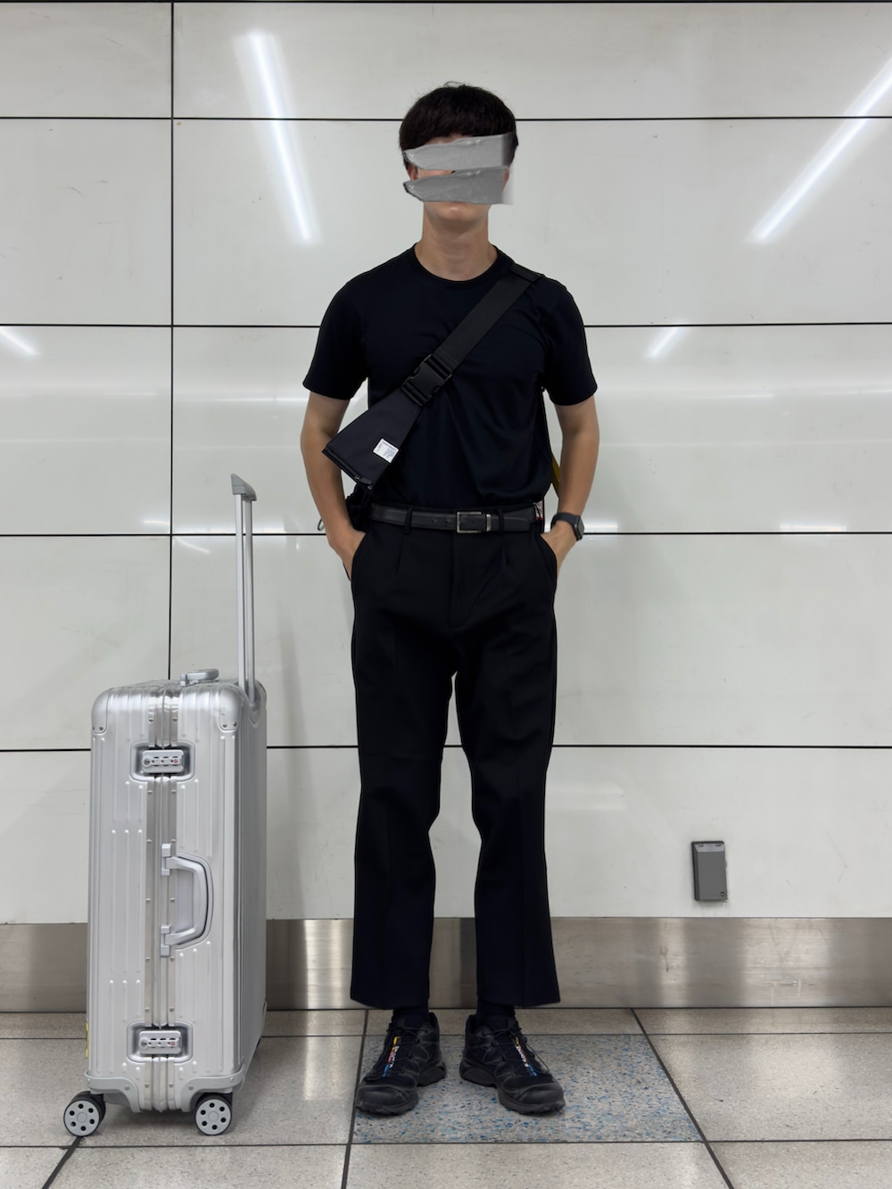 ブラック系のスニーカー、ブラック系のスラックス、シルバー系のスーツケース/キャリーバッグを着用したメンズの秋コーディネートの2枚目の写真